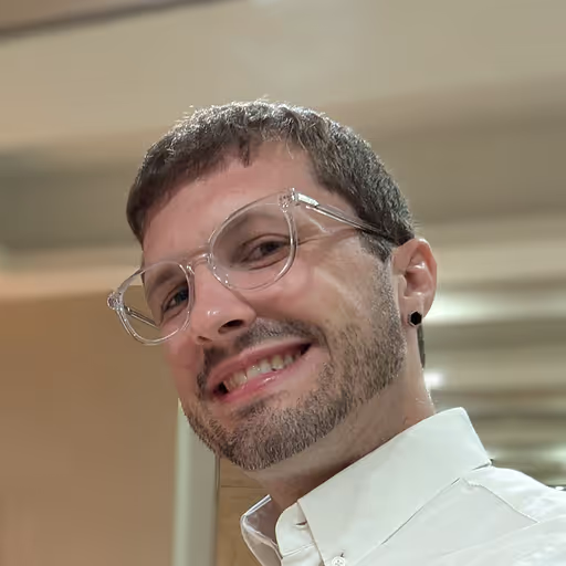 Smiling man with glasses and a beard, tilted portrait