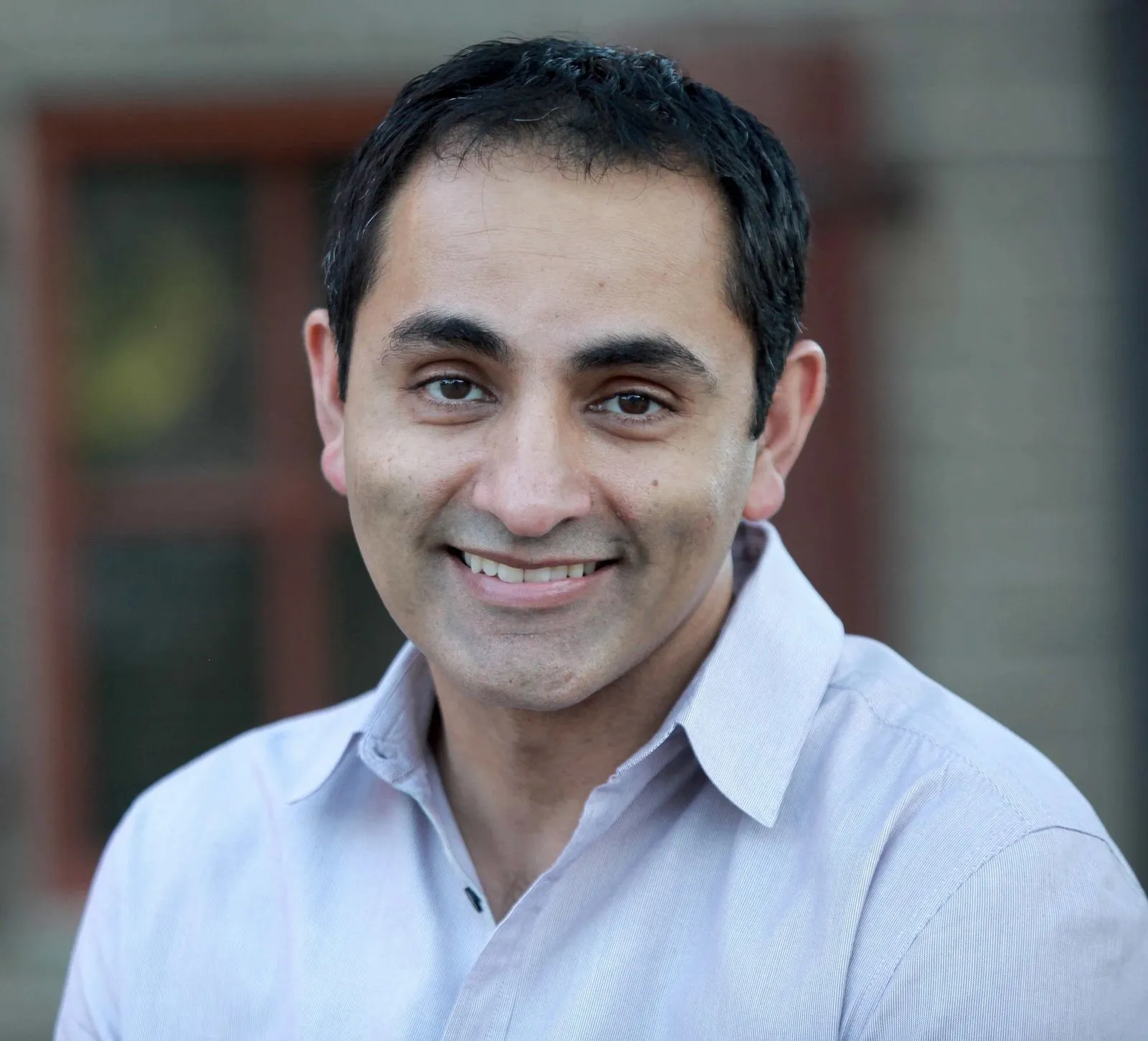 Portrait of a smiling man in a light collared shirt