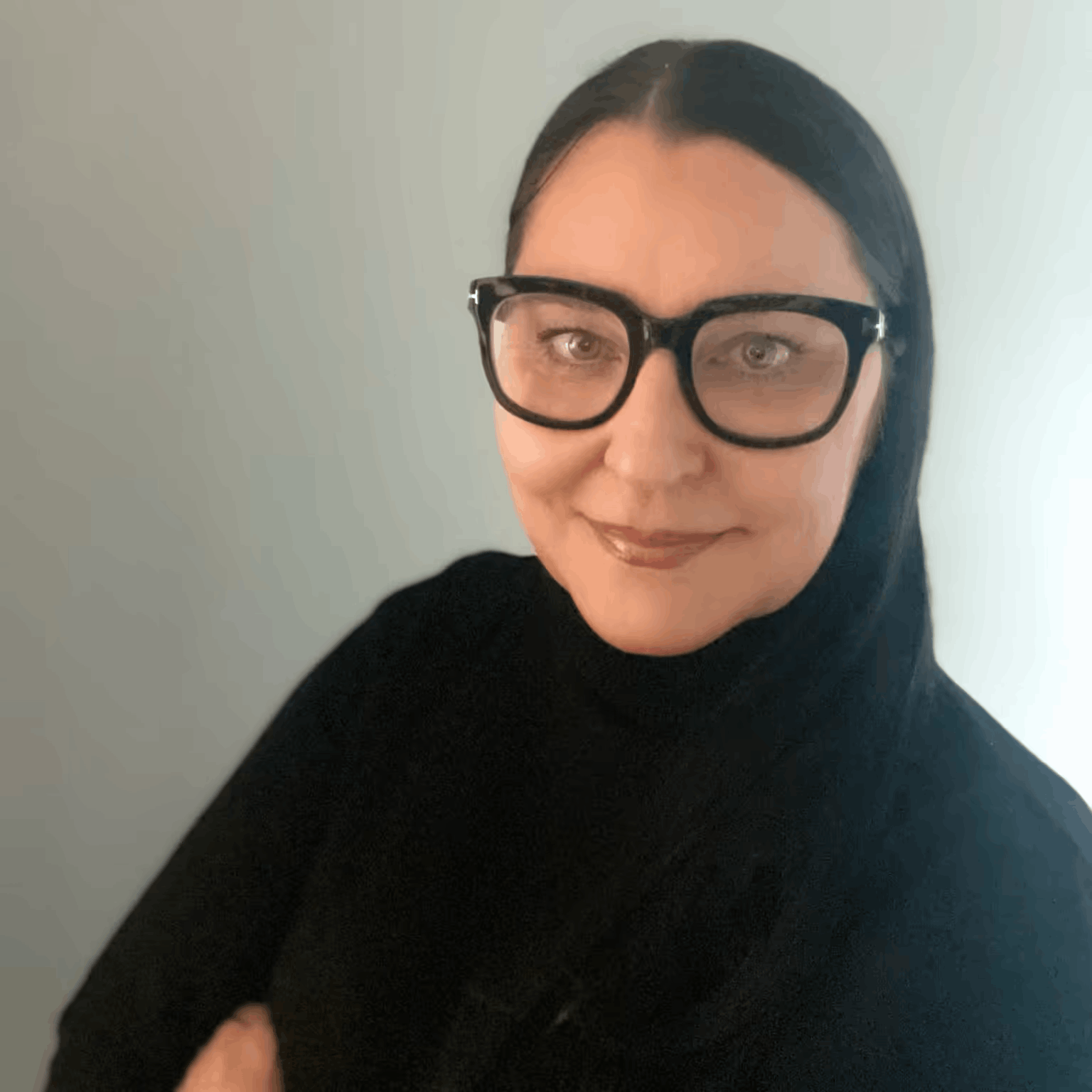 Portrait of a woman with dark hair and large black glasses