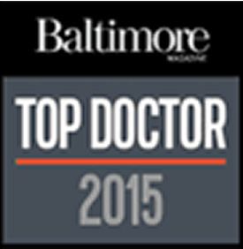 A logo featuring the text 'Baltimore Magazine' at the top, with the words 'TOP DOCTOR' in large, bold, white letters below, and the year '2015' in smaller, gray letters beneath it, along with an orange horizontal line separating 'TOP DOCTOR' and '2015'.