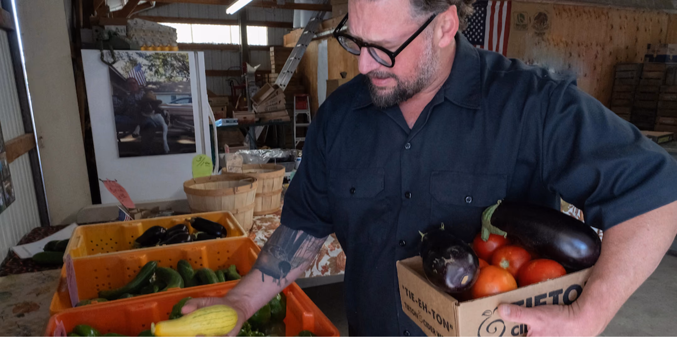 Chef carrying a crate of fresh garden vegetables