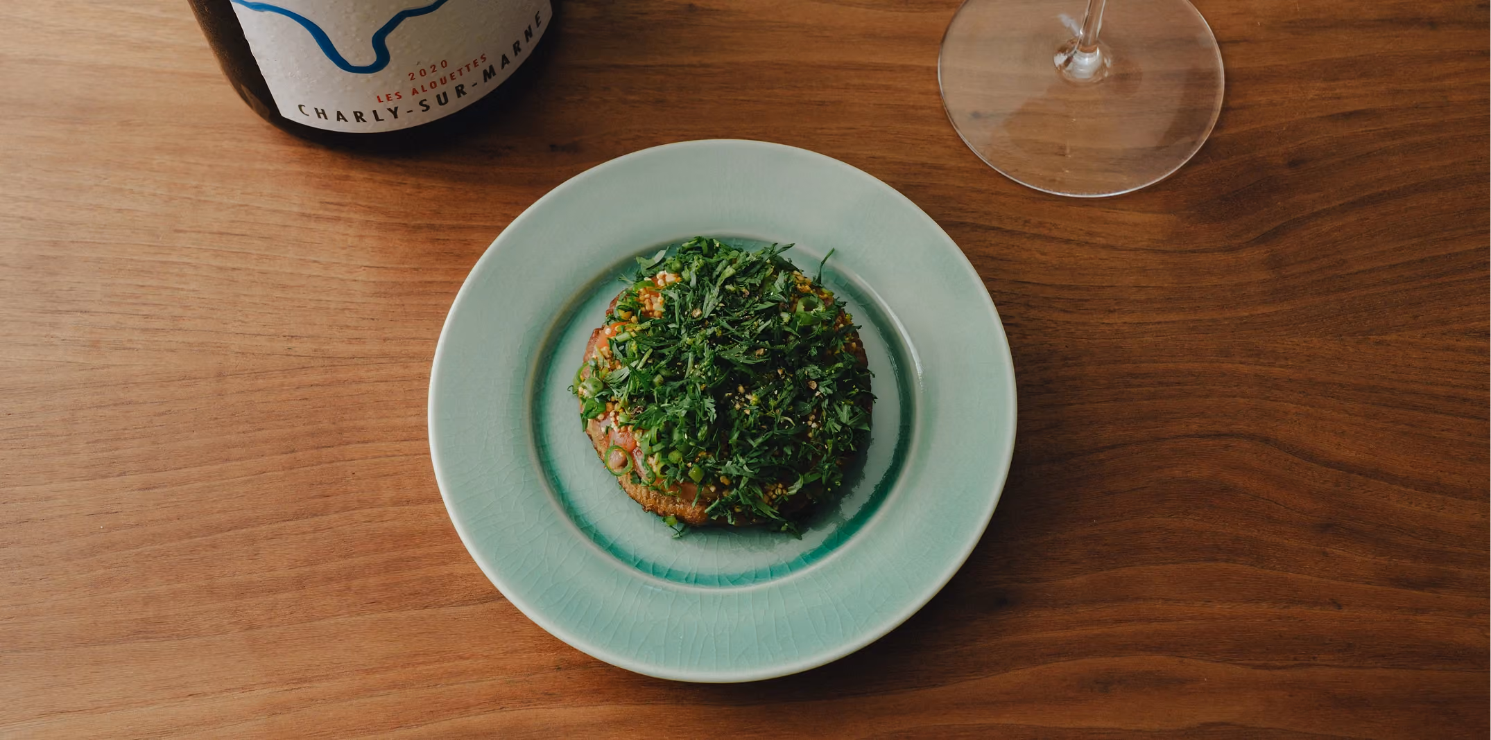 Herb-crusted dish on a celadon plate with Champagne 9	Chef foraging sumac in the garden