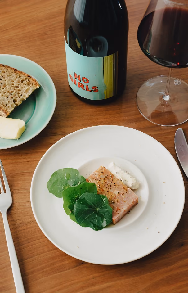 Fish course with fresh greens and a glass of red wine