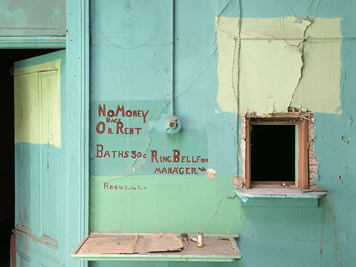 Weathered turquoise building with vintage hand-painted signage
