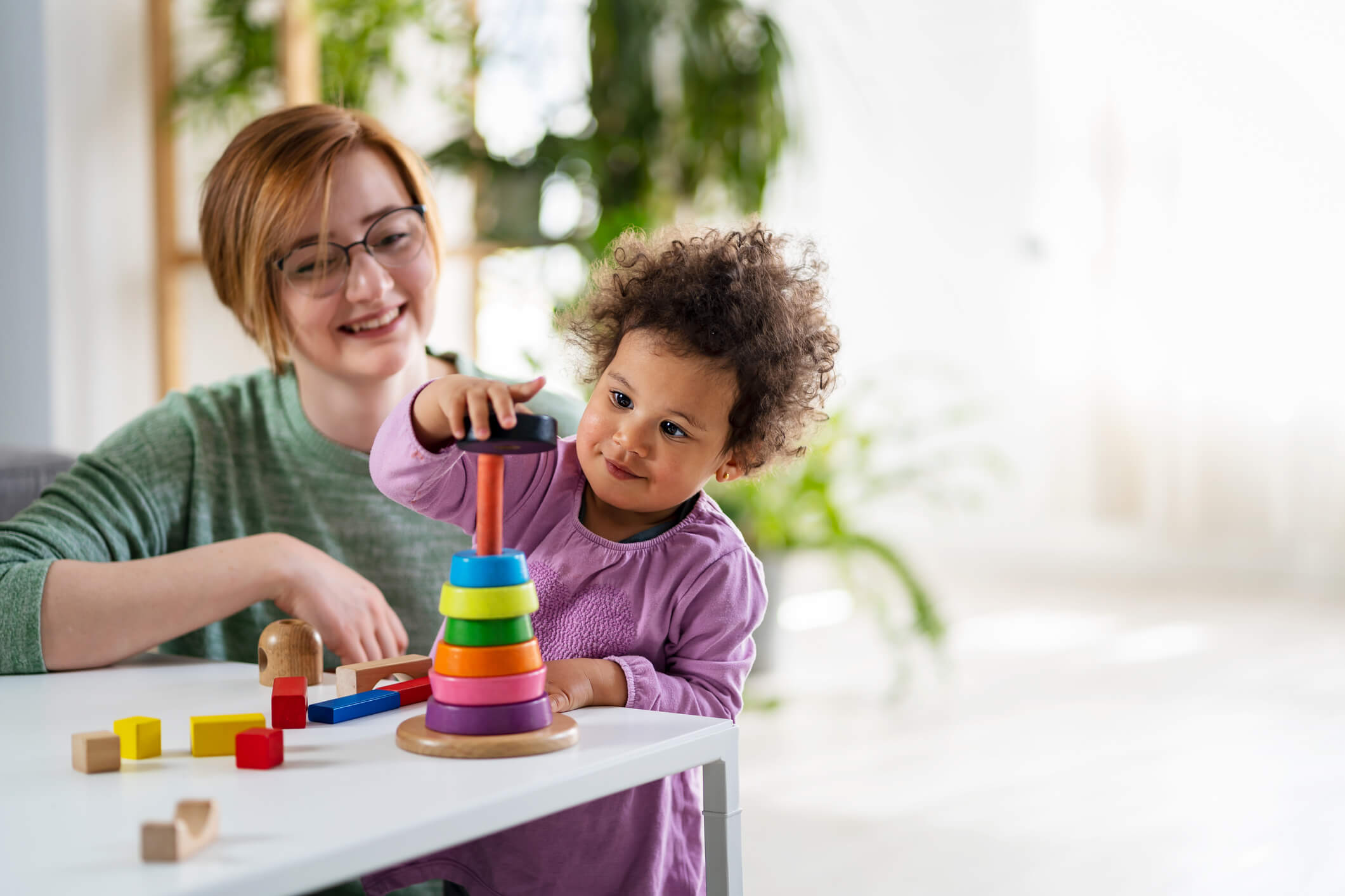 Toddler in play-based therapy with a therapist