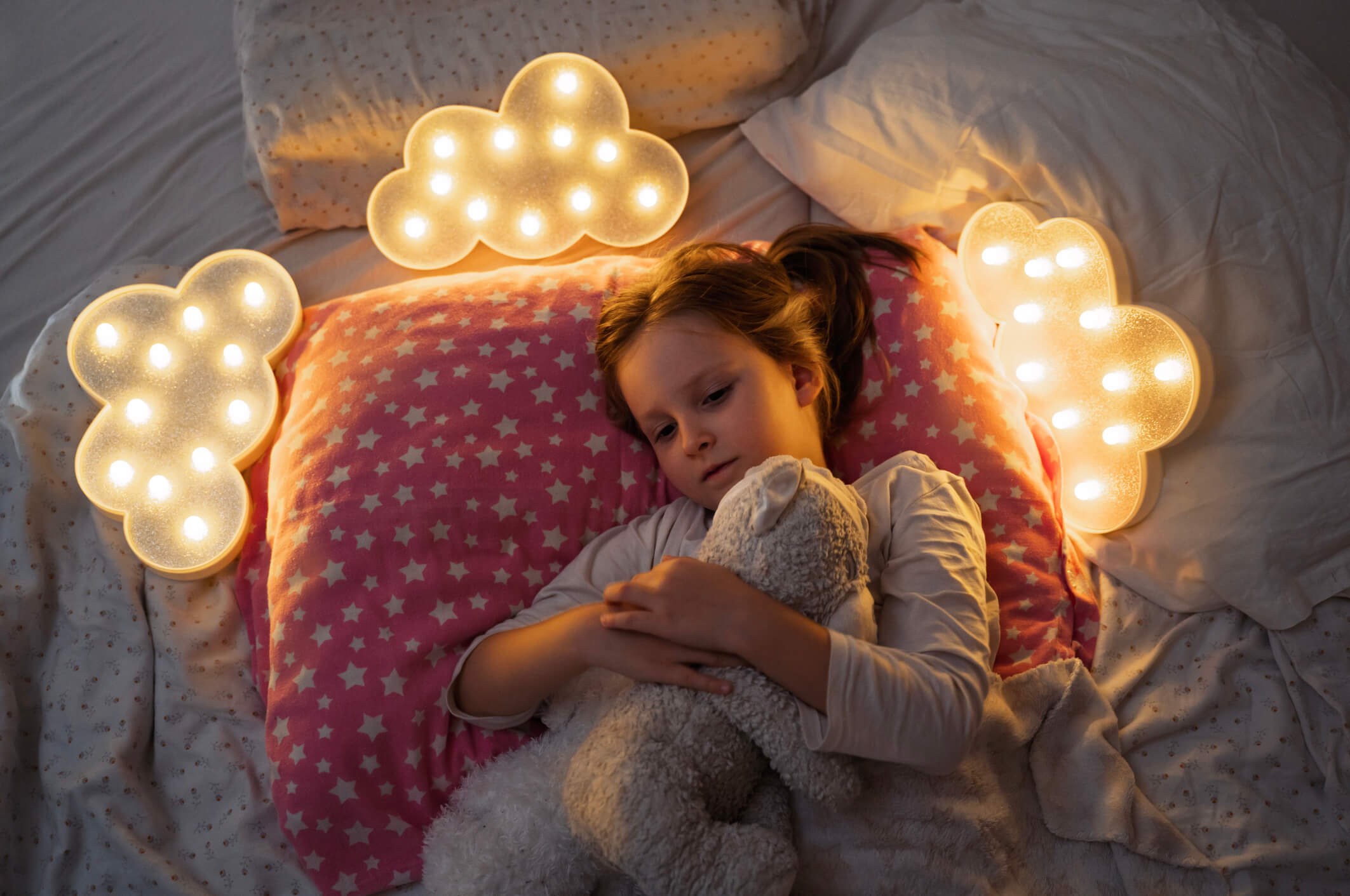 Calm child resting in bed in a softly lit room