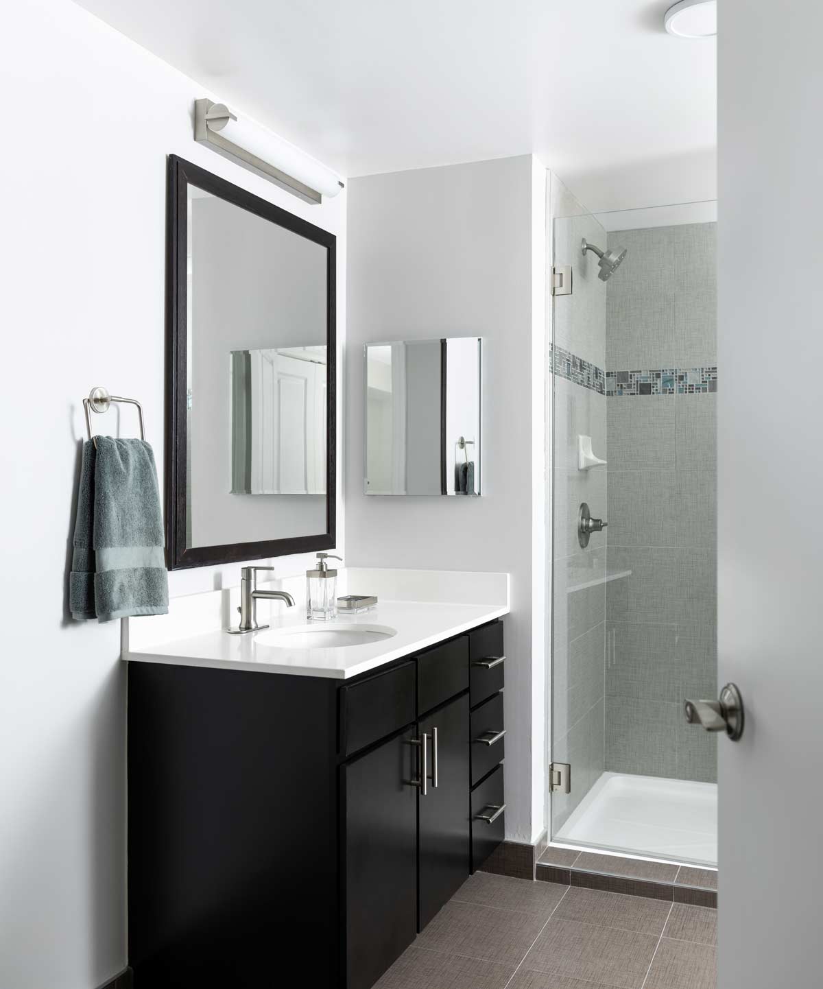 Lyric apartment bathroom with a vanity and glass-enclosed shower