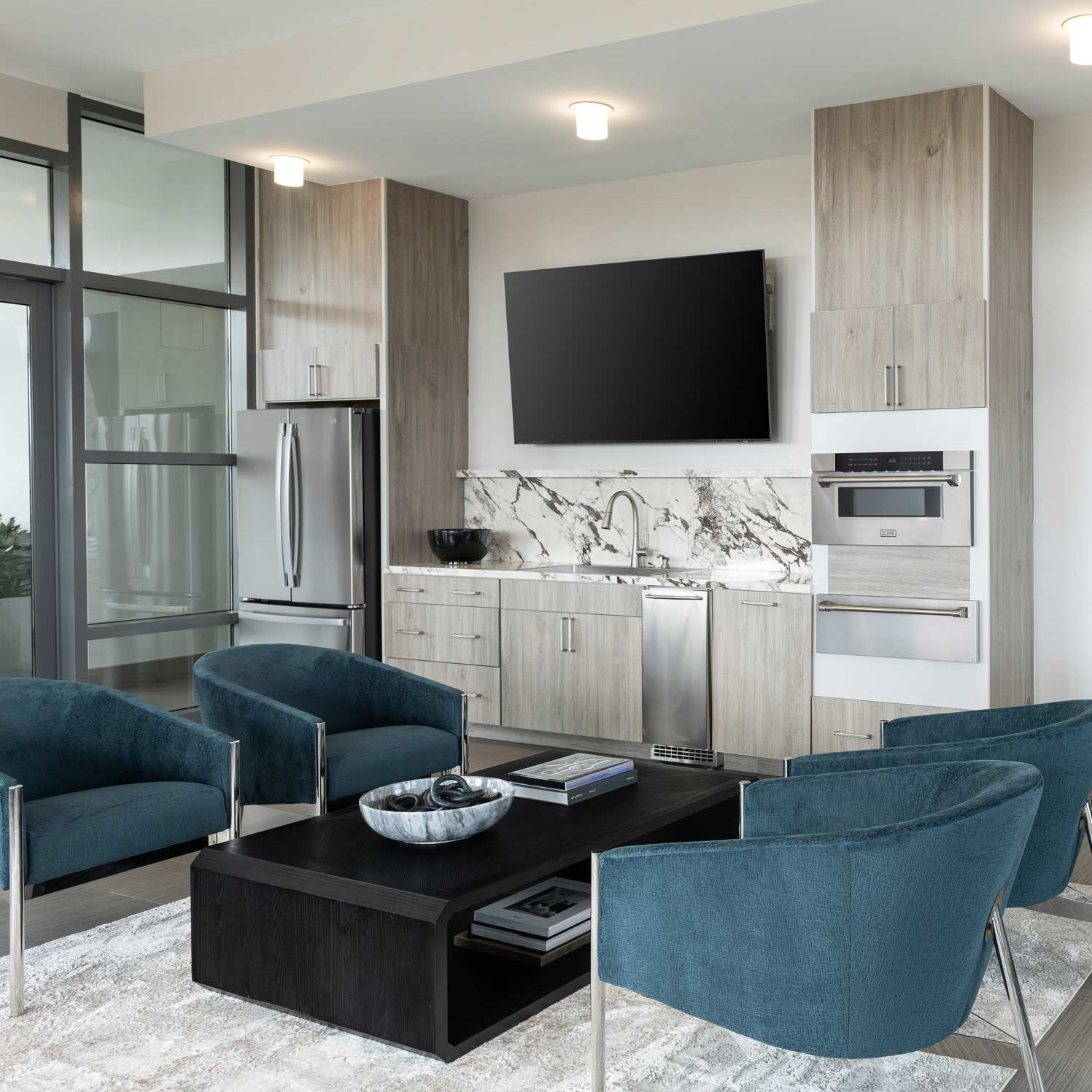Lyric rooftop lounge with blue seating, a television, and a shared kitchen