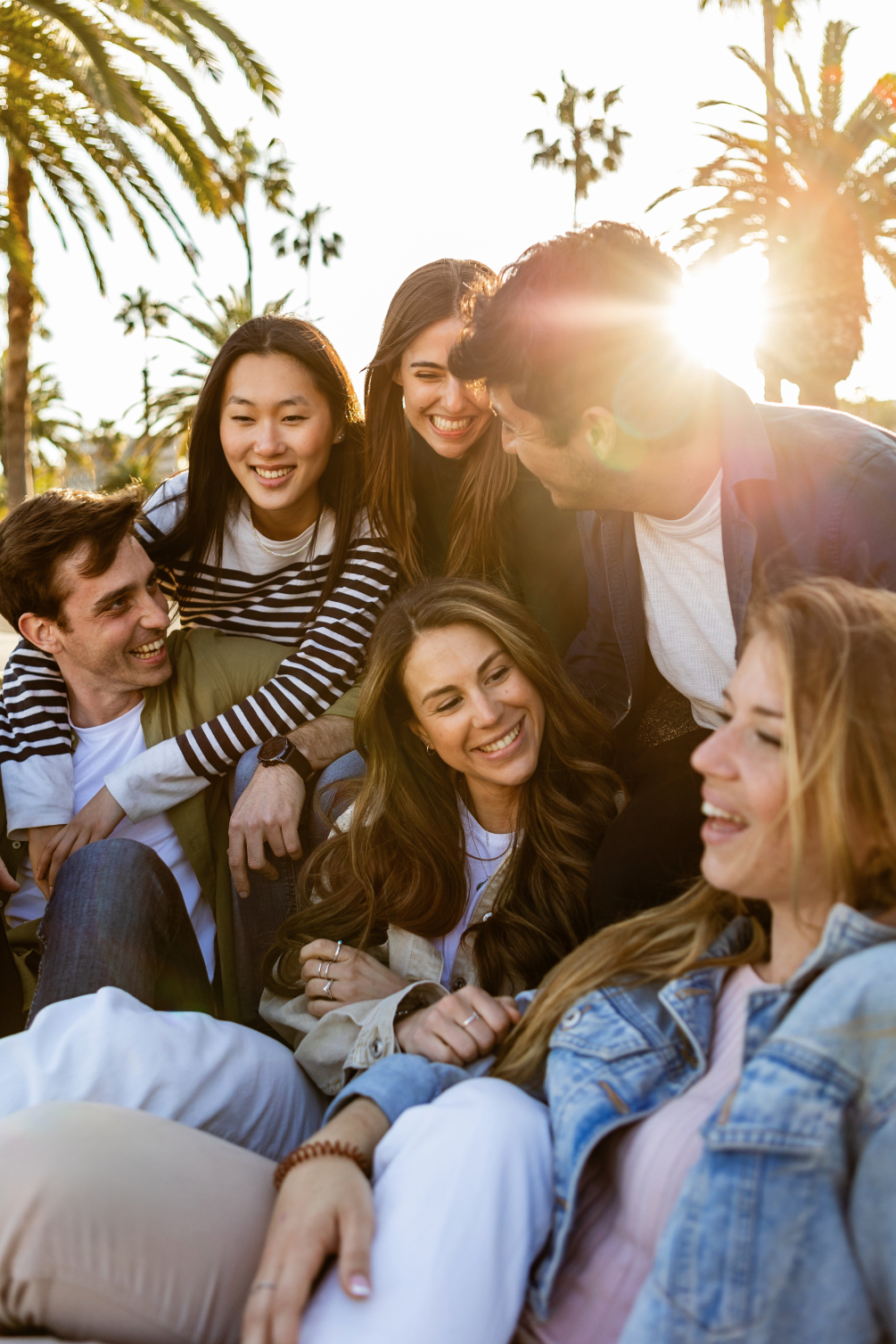 Friends gather under palm trees stock image