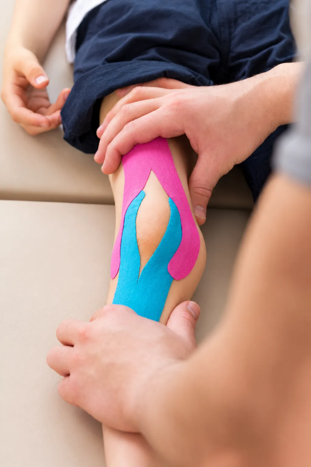 Supportive tape being applied around a patient’s knee