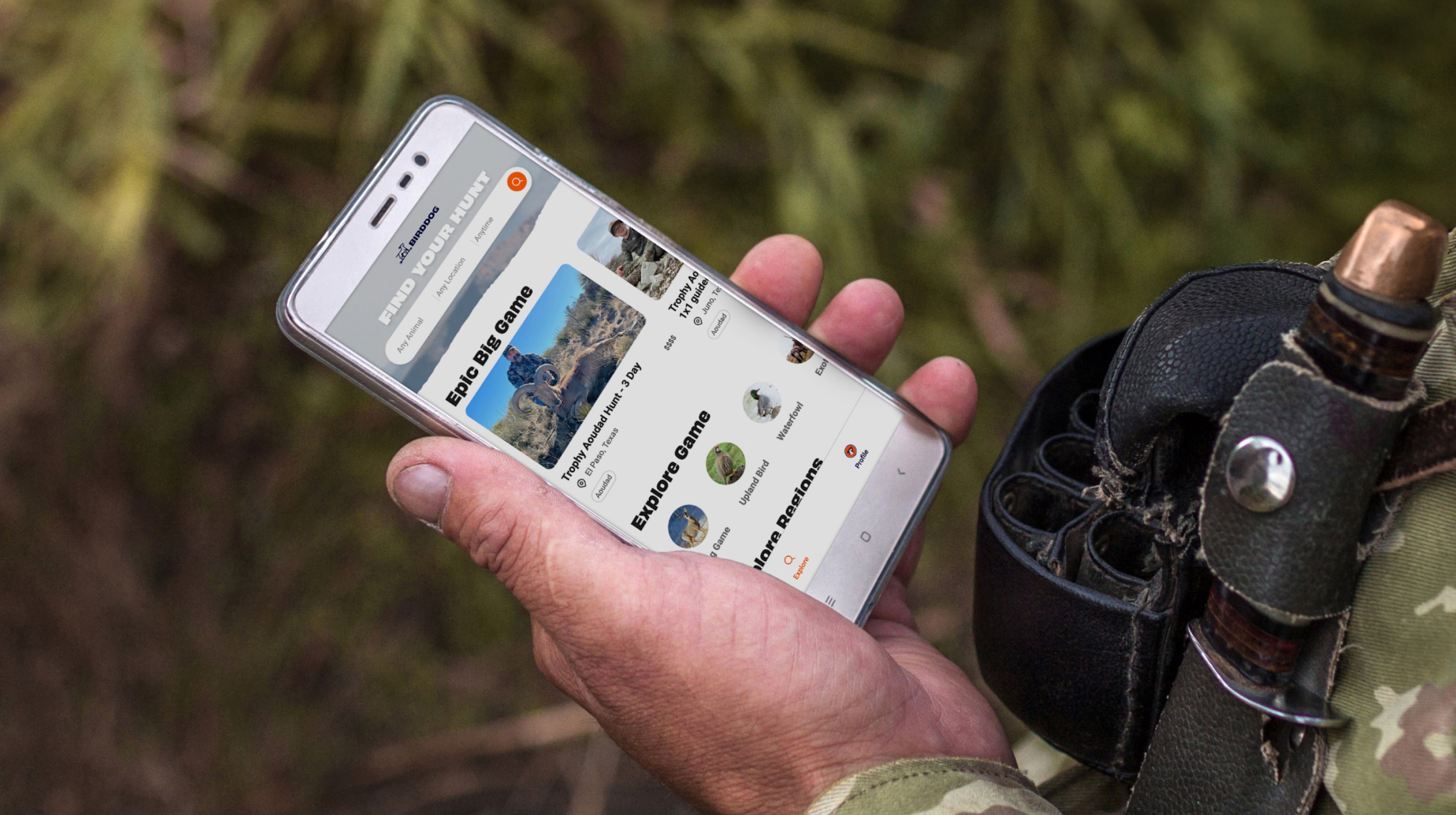 Person holding phone displaying a hunting app with options for big game and exploring game types.