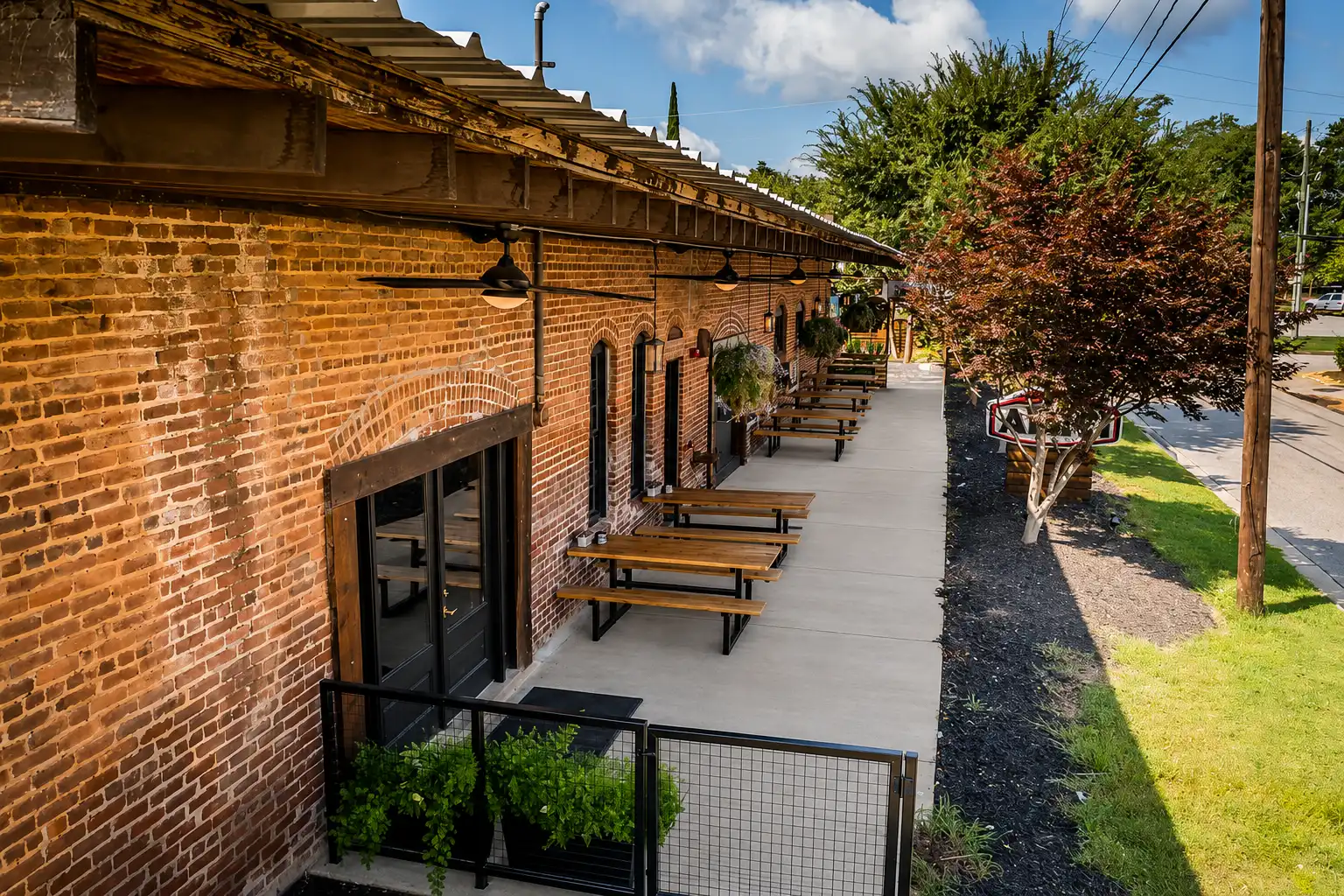 Renovated brick commercial building with a covered patio and picnic tables