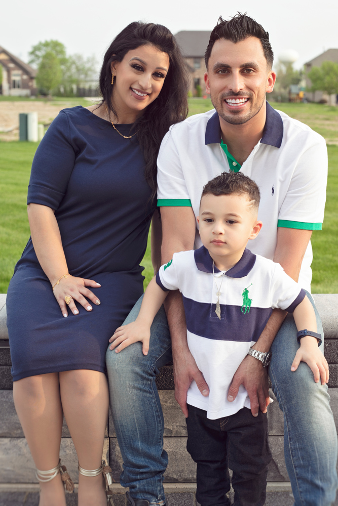 Firas Isa with his wife Sabreen Rihan and their son Adriyan Isa posing together outdoors.