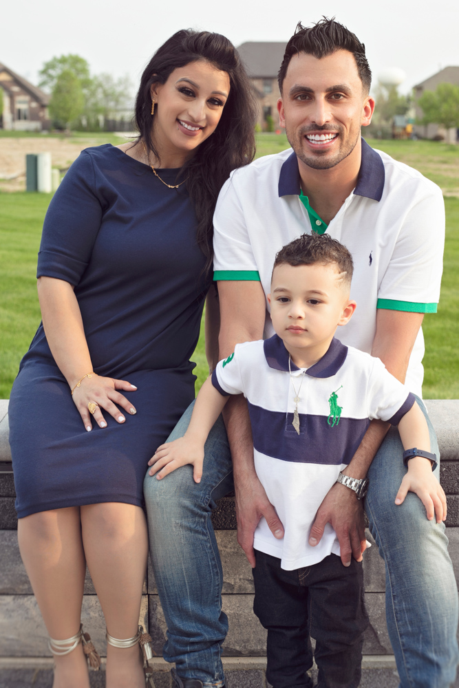 Firas Isa with his wife Sabreen Rihan and their son Adriyan Isa posing together outdoors.