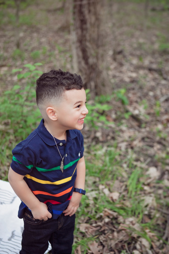 Adriyan Isa looking to the side while standing among the trees.