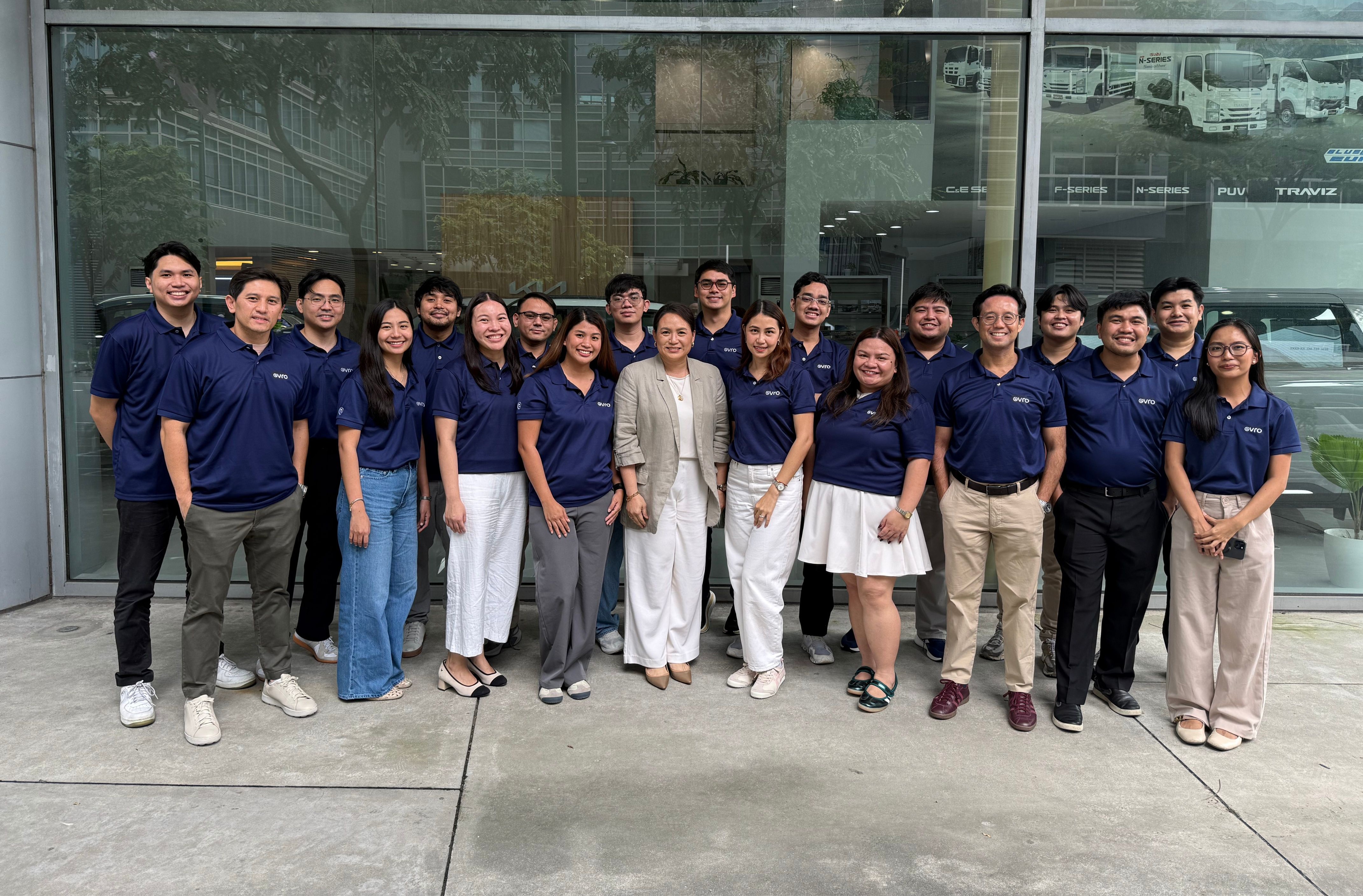 Evro team posing together outside a glass building.