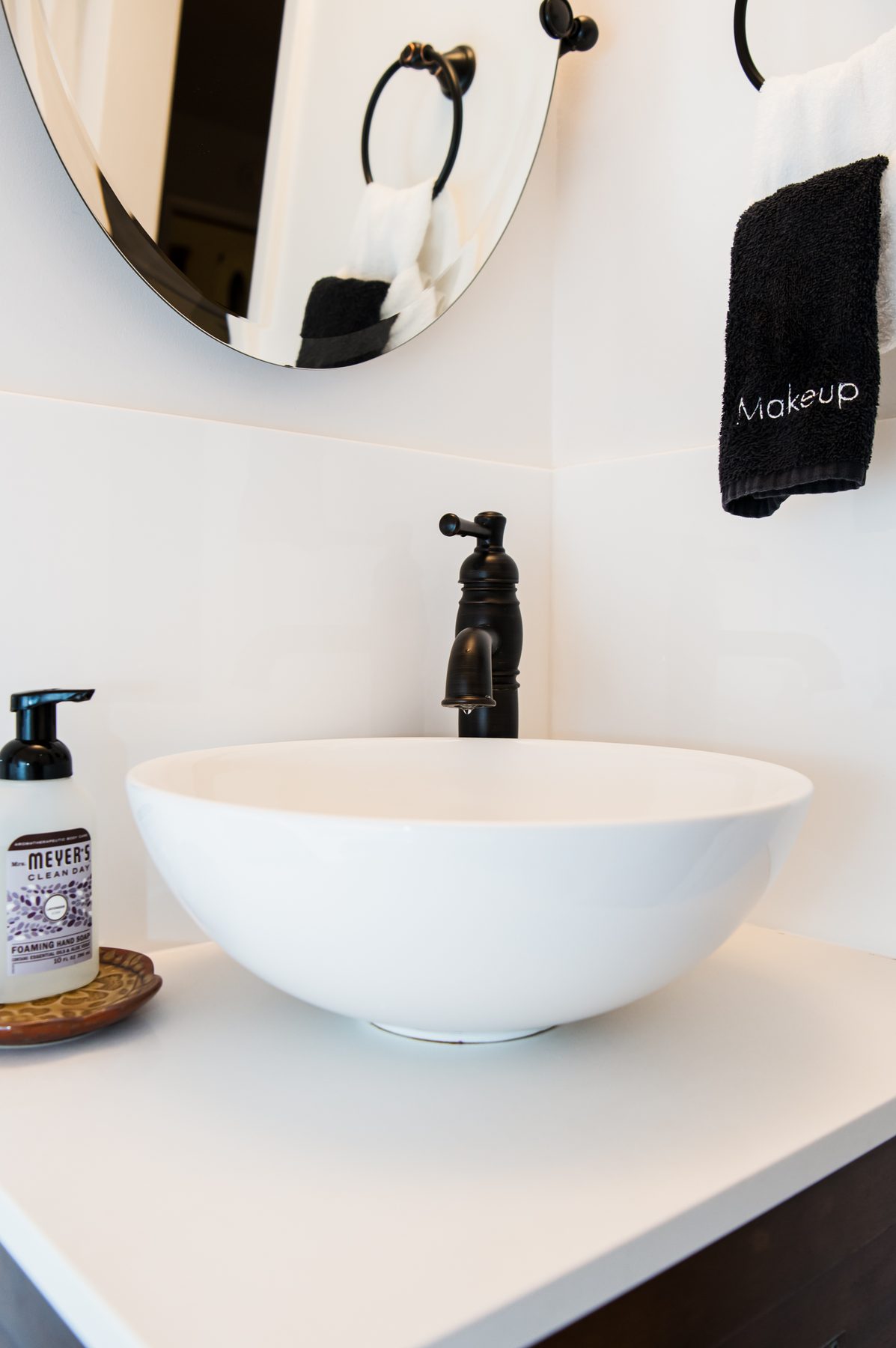 Bathroom vanity with a white vessel sink and oil-rubbed bronze fixtures
