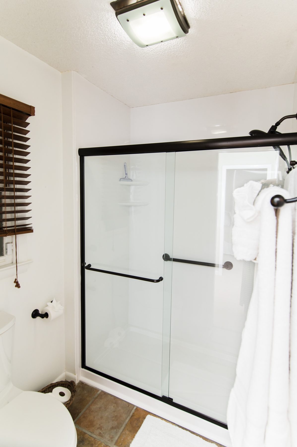 Walk-in glass shower with oil-rubbed bronze fixtures