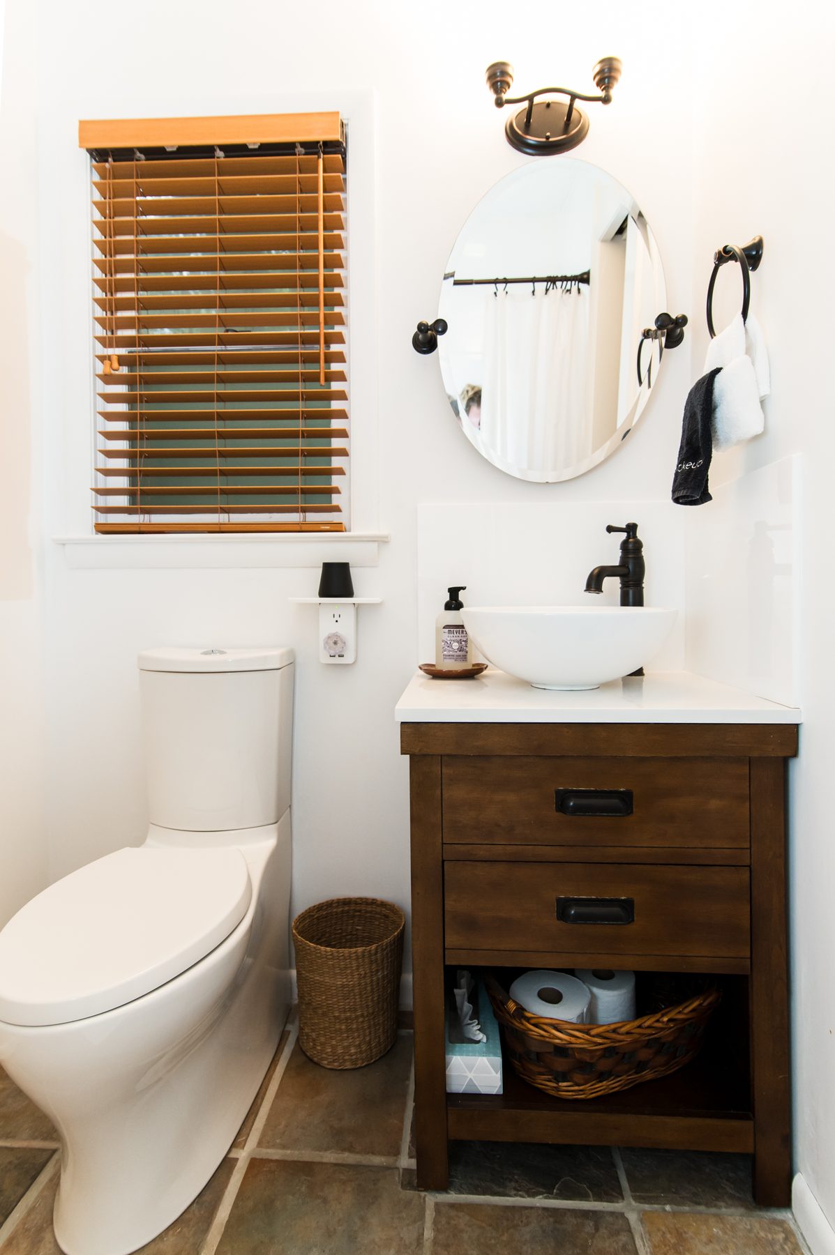 Bright bathroom with a vessel-sink vanity, wood blinds and slate-tile floor