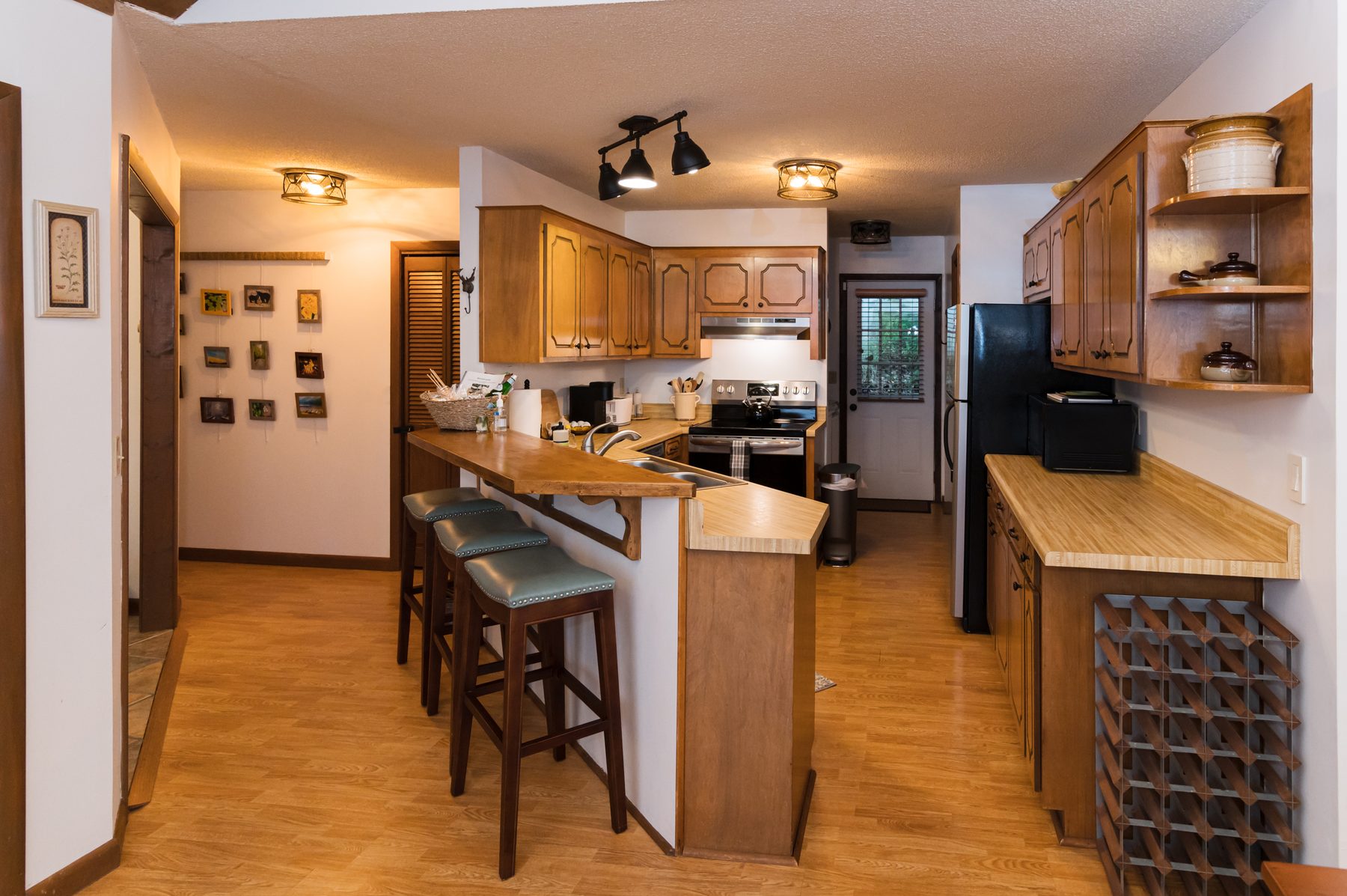 Kitchen with a breakfast bar and stainless appliances at The Woodland Cottage in Sapphire, NC