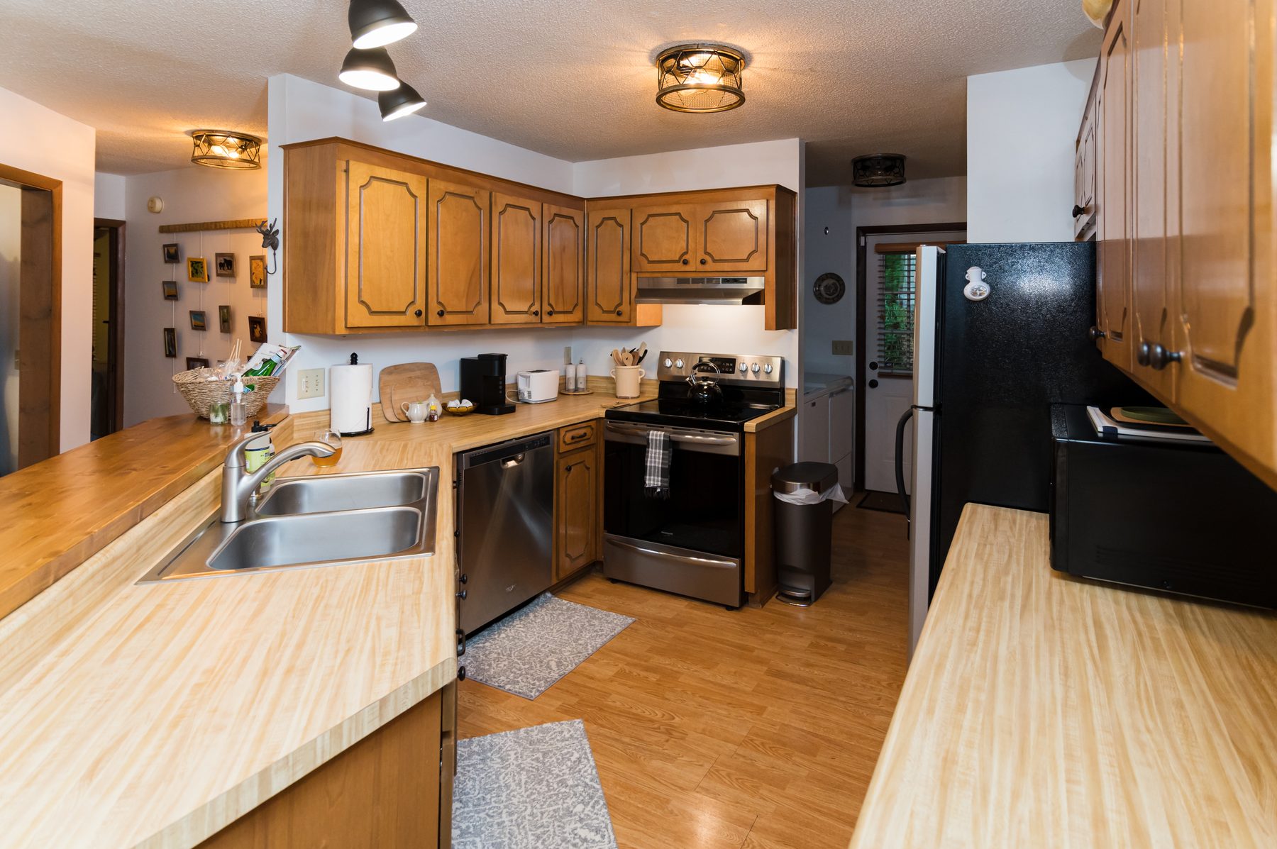 Full kitchen with stainless appliances, butcher-block counters and wood cabinetry at The Woodland Cottage