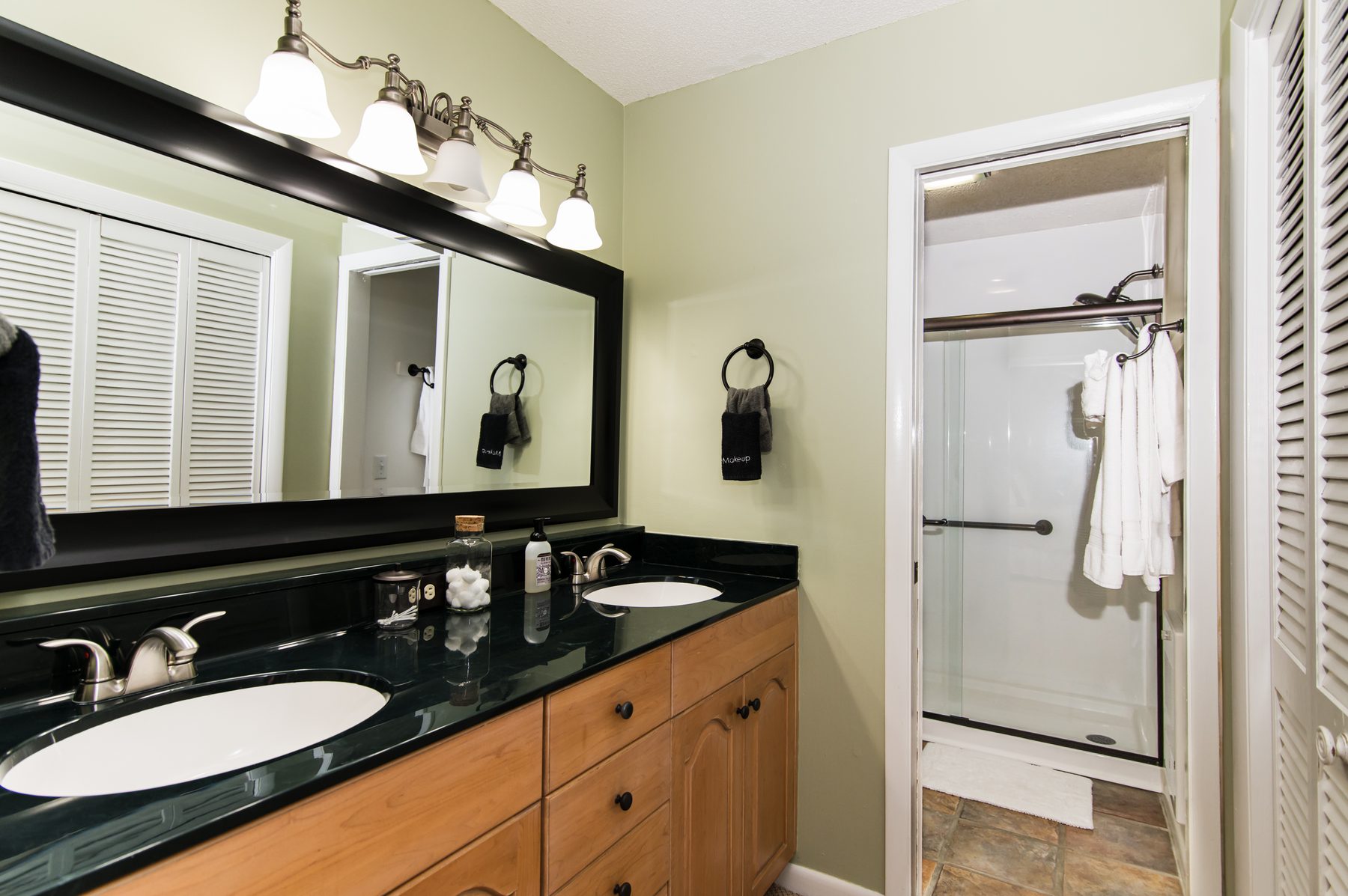 Bathroom with a double vanity, framed mirror and walk-in shower