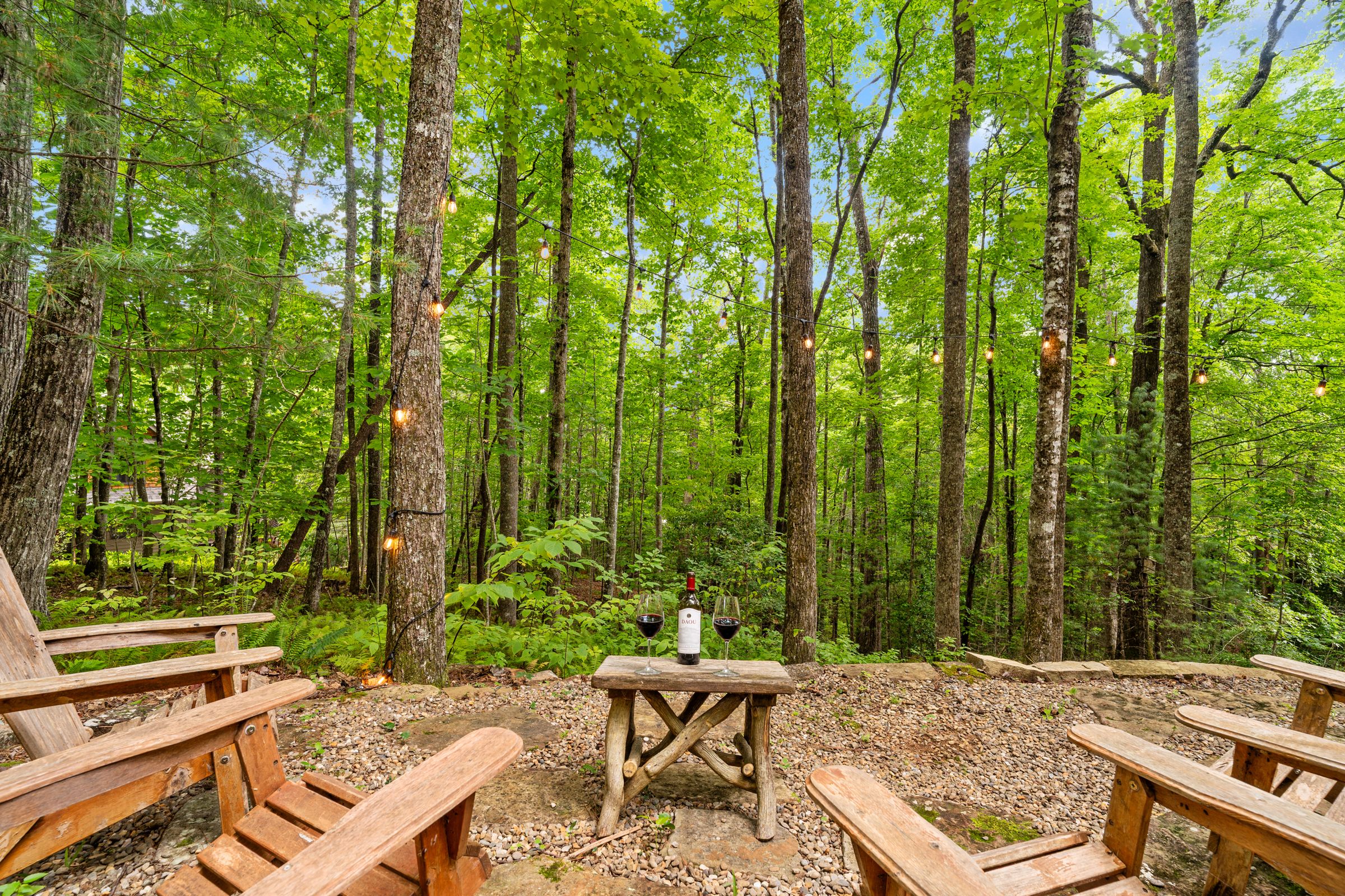 Adirondack chairs around the woodland firepit in daylight