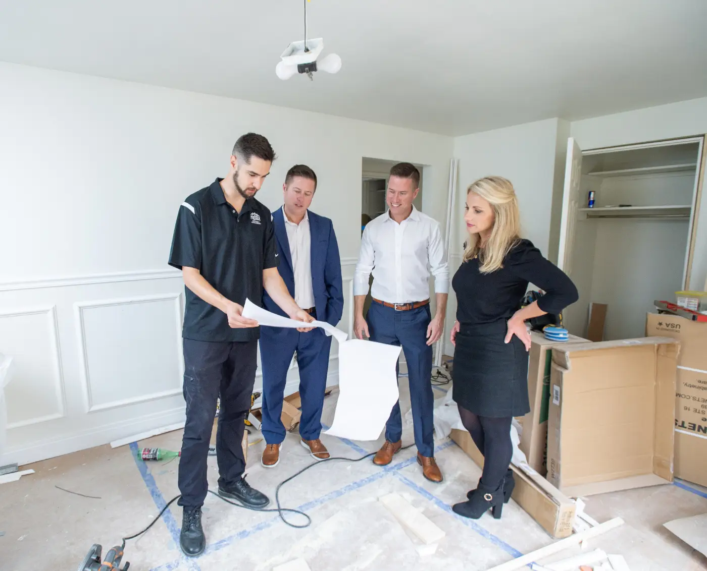 Mitch Painter inspecting interior renovation blueprints with the Prestige Properties project team