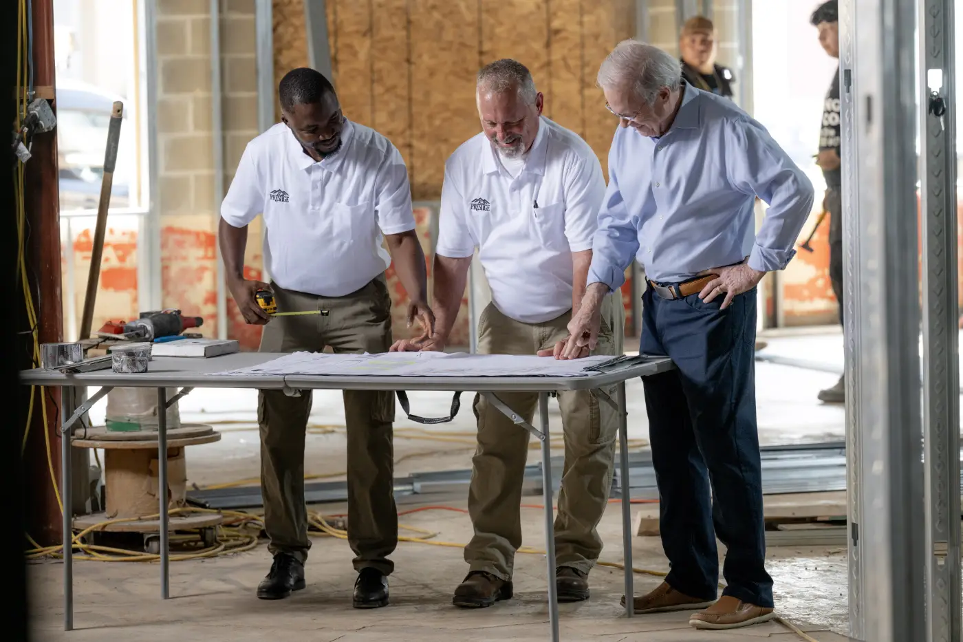 Prestige Properties team reviewing construction plans during a property development site inspection.