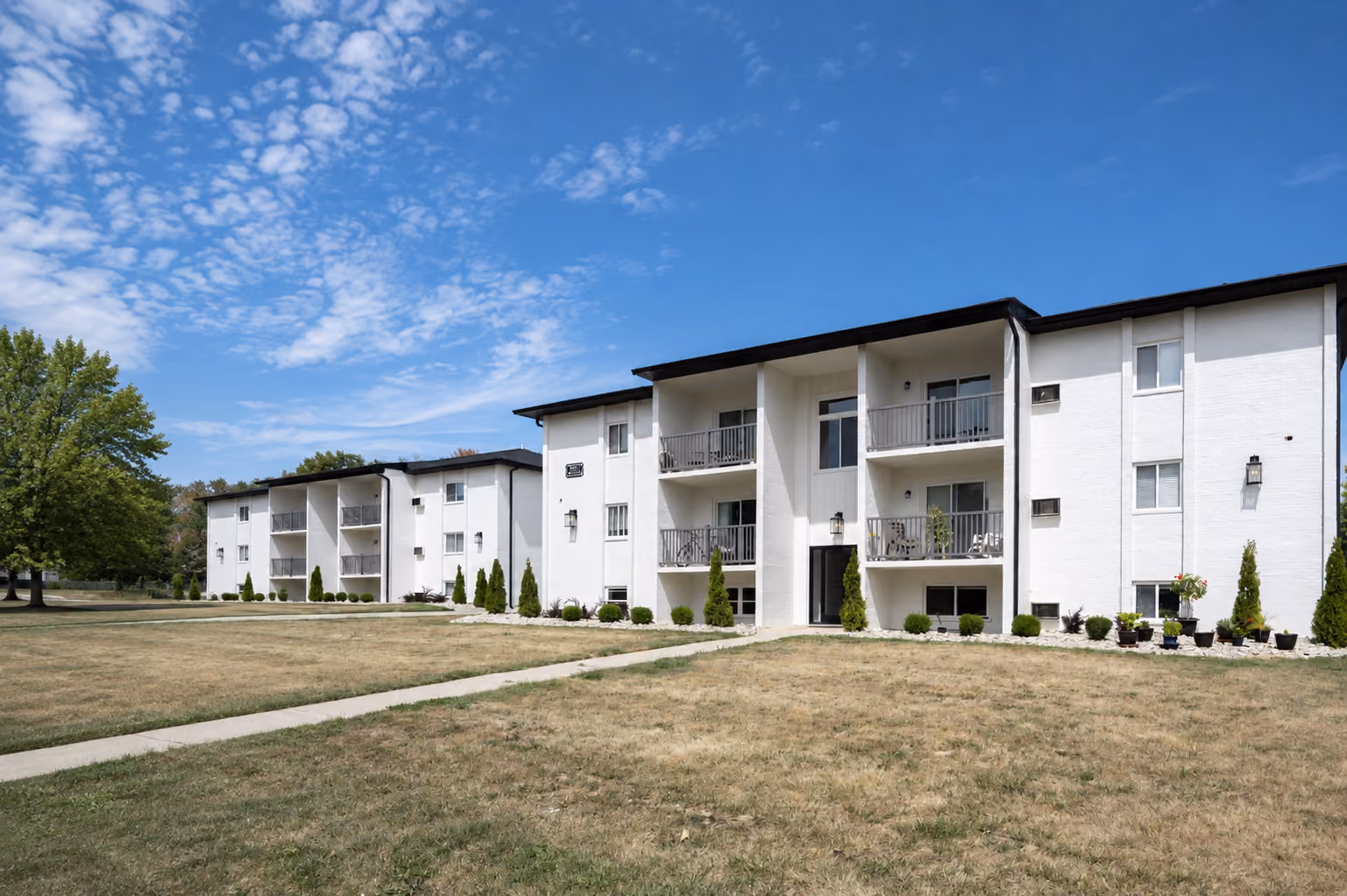 Exterior view of a modern apartment building represented by Prestige Properties.