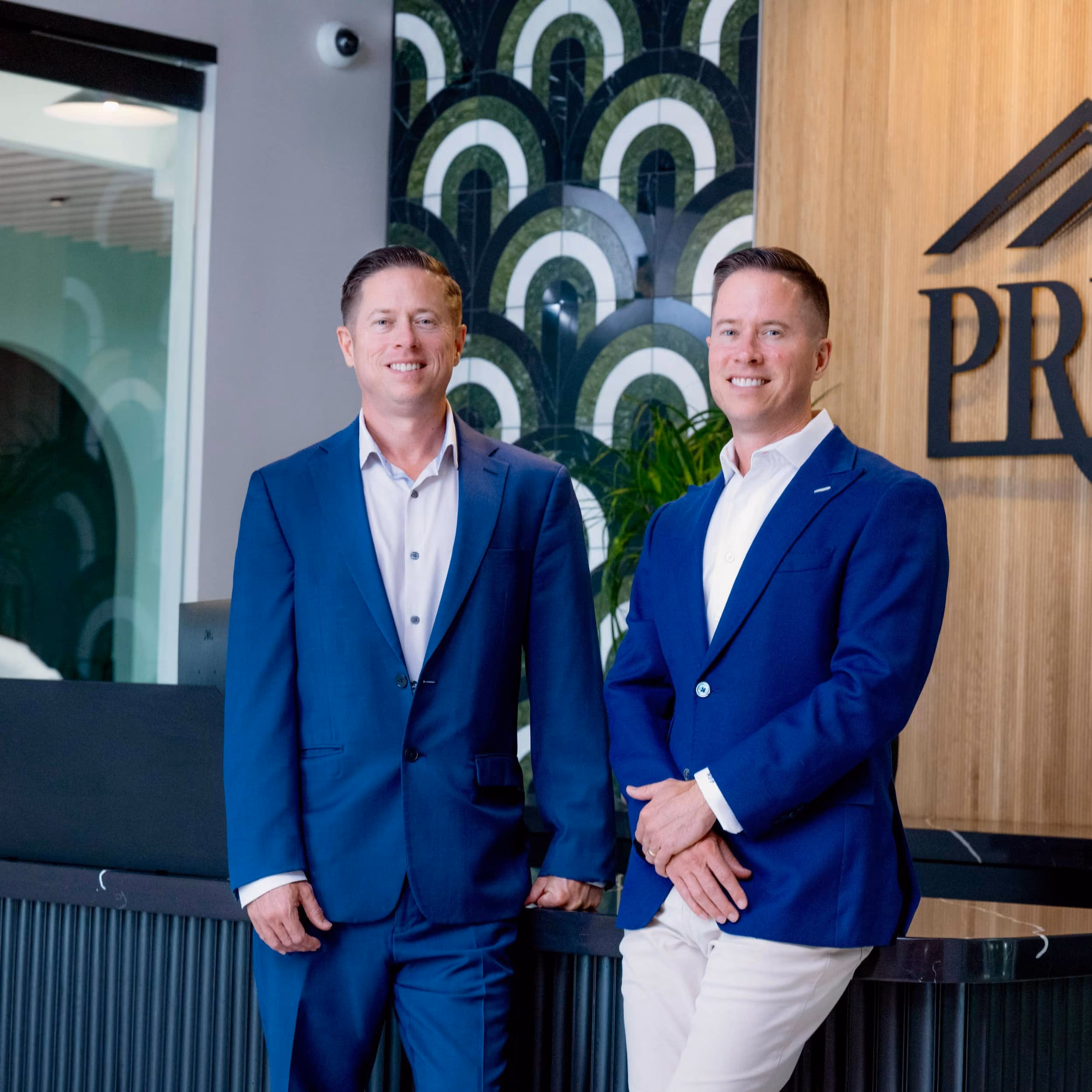 Mitch Painter and partner standing at the Prestige Properties office reception area