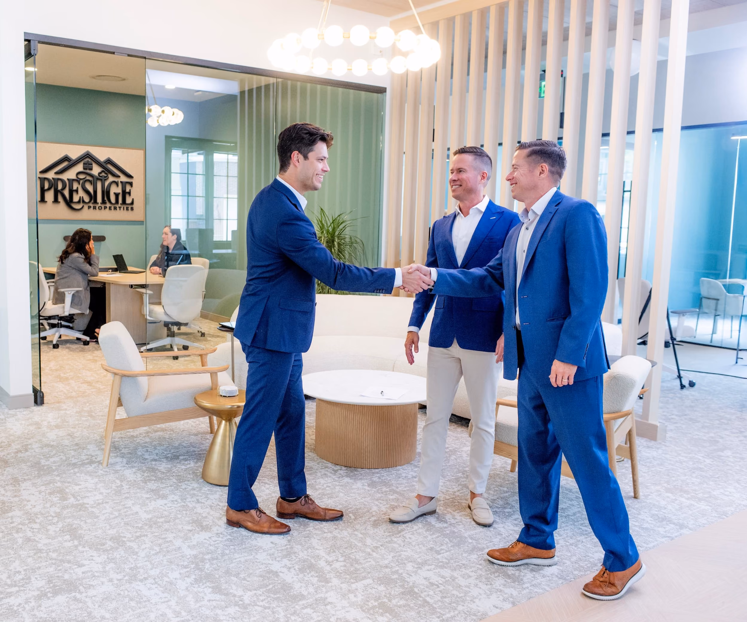 Mitch Painter and Prestige team shaking hands with an investor in office lobby