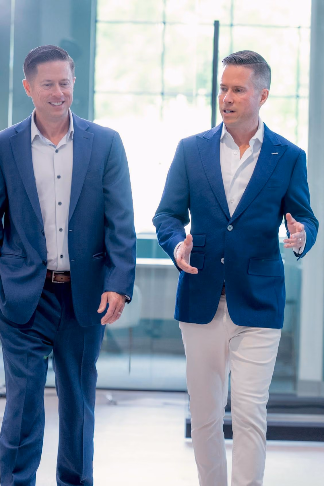 Matt Painter and Mitch Painter walking and talking through the modern office building