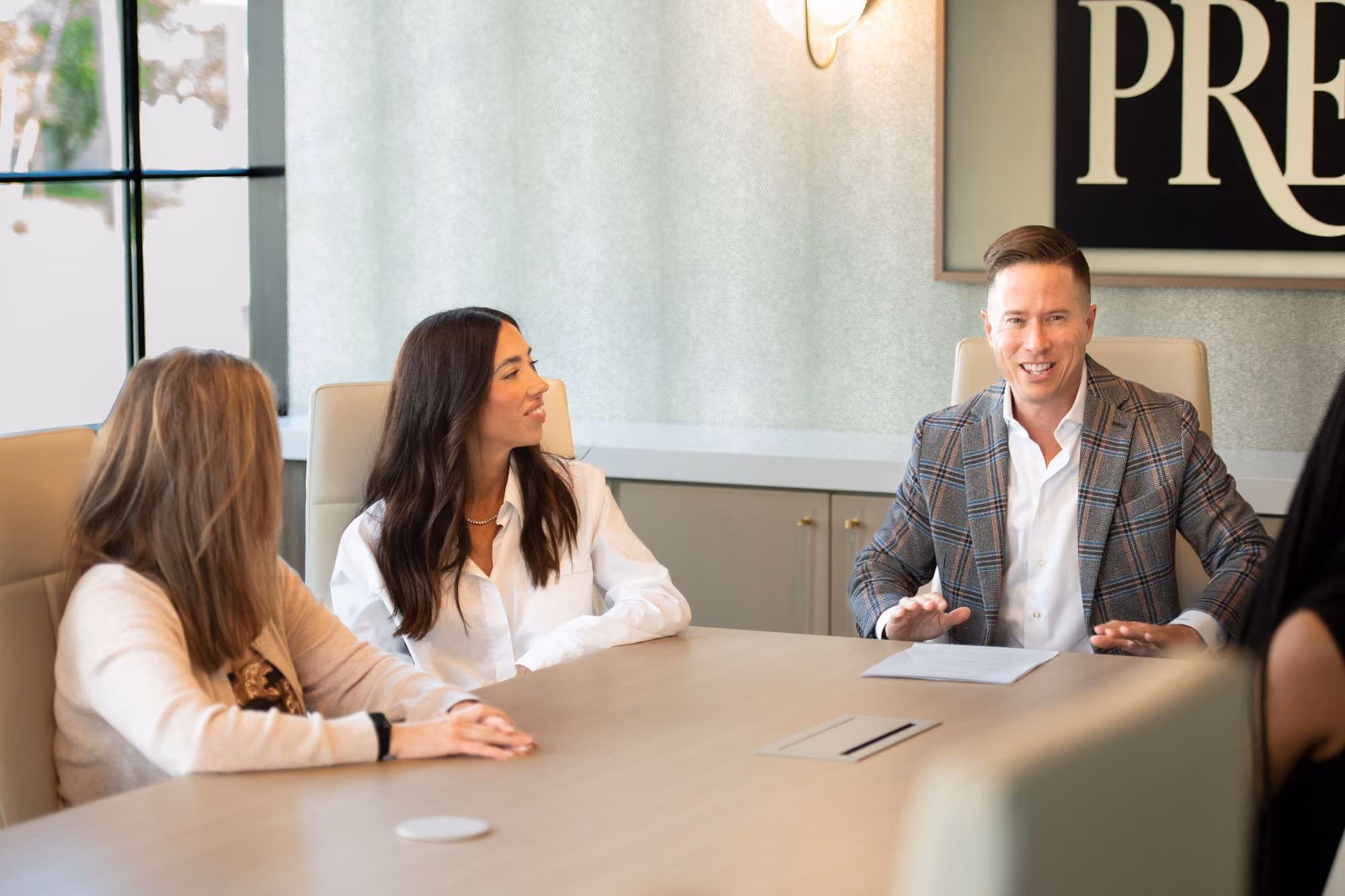 Mitch Painter leading a team meeting at a conference table in the Prestige Properties office