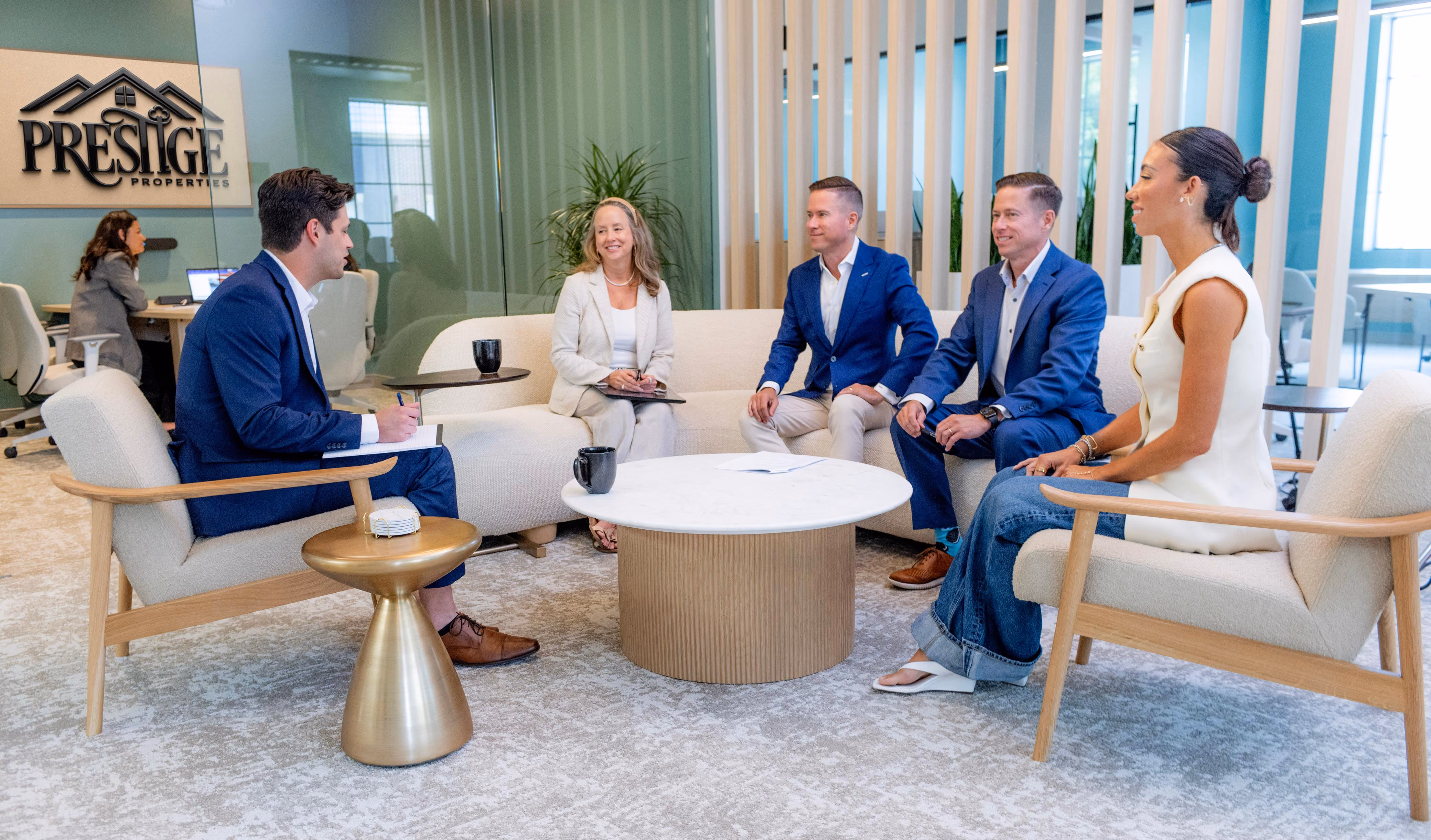 Mitch Painter and Prestige leadership team discussing investment metrics in office lounge setting