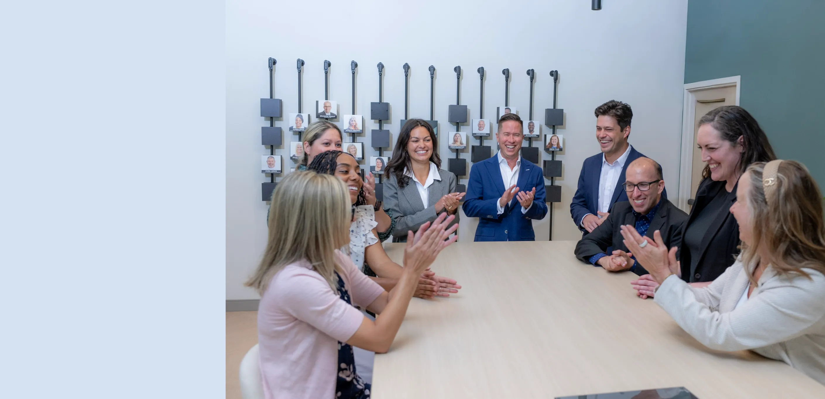 Mitch Painter and Prestige Properties team members applauding around a conference room table