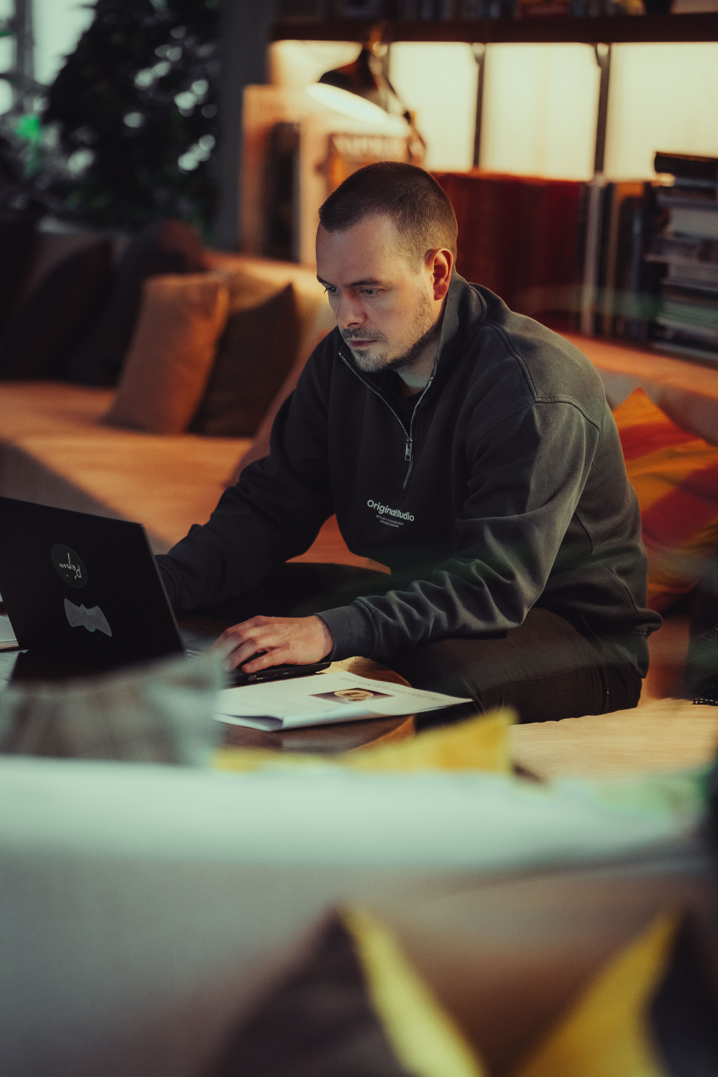 Lucien Vanwerts travaillant sur son ordinateur portable dans un lounge chaleureux