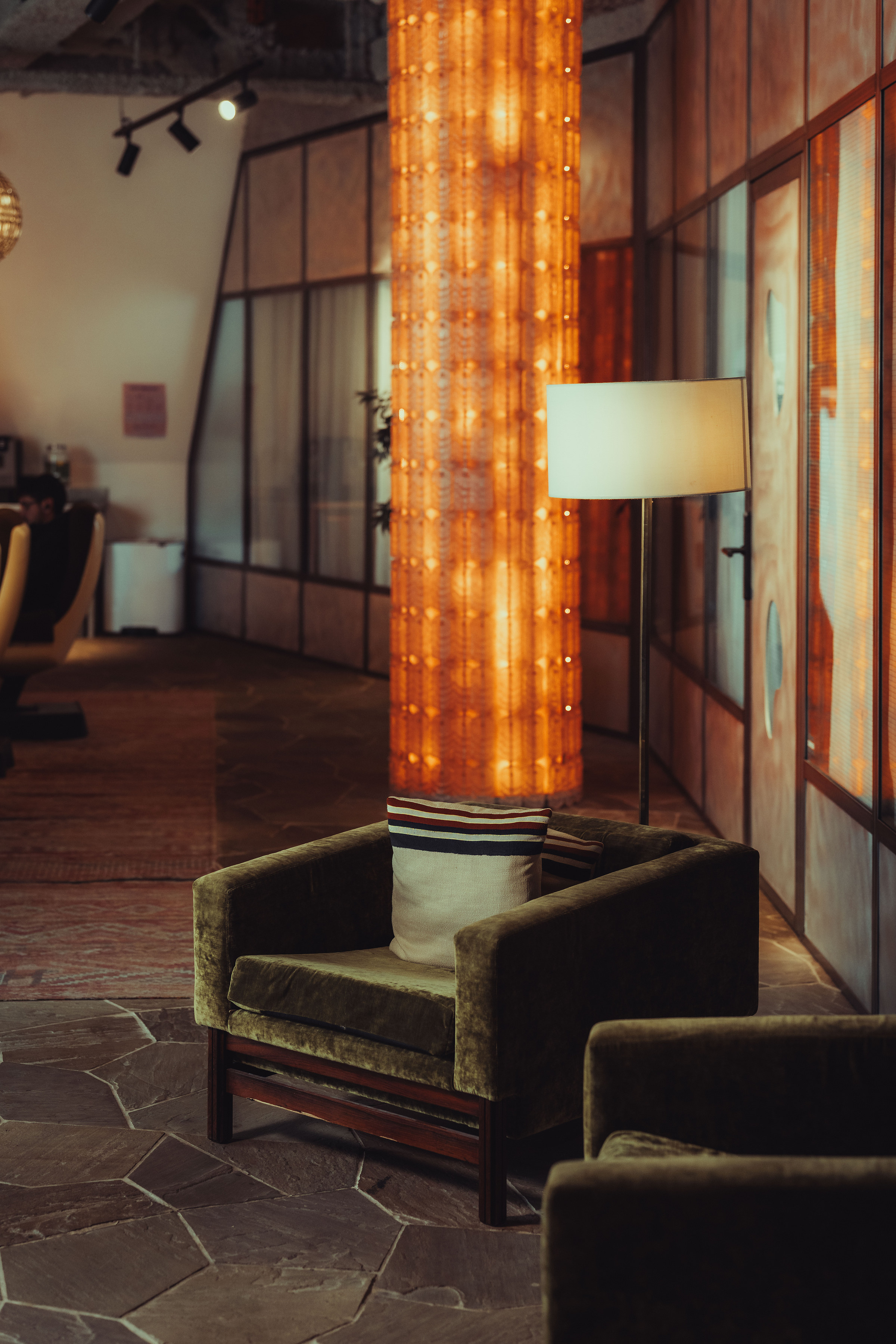 Fauteuil en velours devant un pilier lumineux, ambiance calme et apaisante