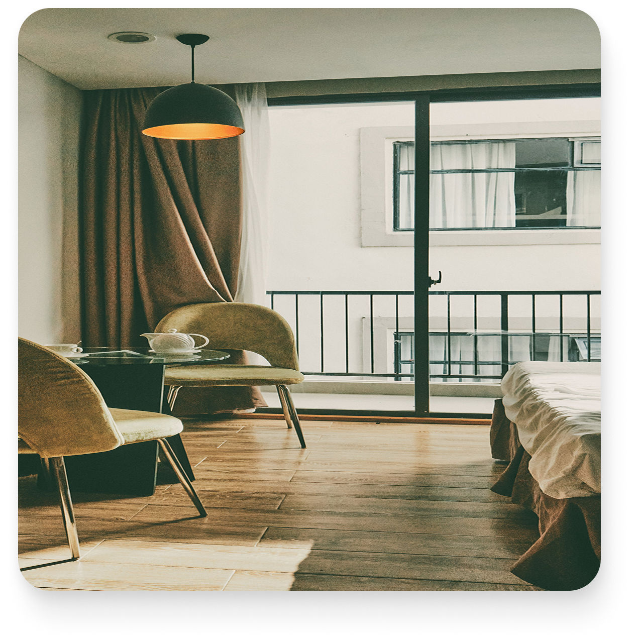 Coin repas avec deux chaises beiges, une table en verre et une porte-fenêtre donnant sur un balcon.