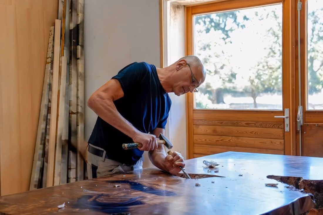 Tischlermeister Beaupoil in Werkstatt mit Massivholz eines einzigartigen Collectible Design Möbels als skulpturales Designobjekt, Esstisch und individuelles Kunstmöbel