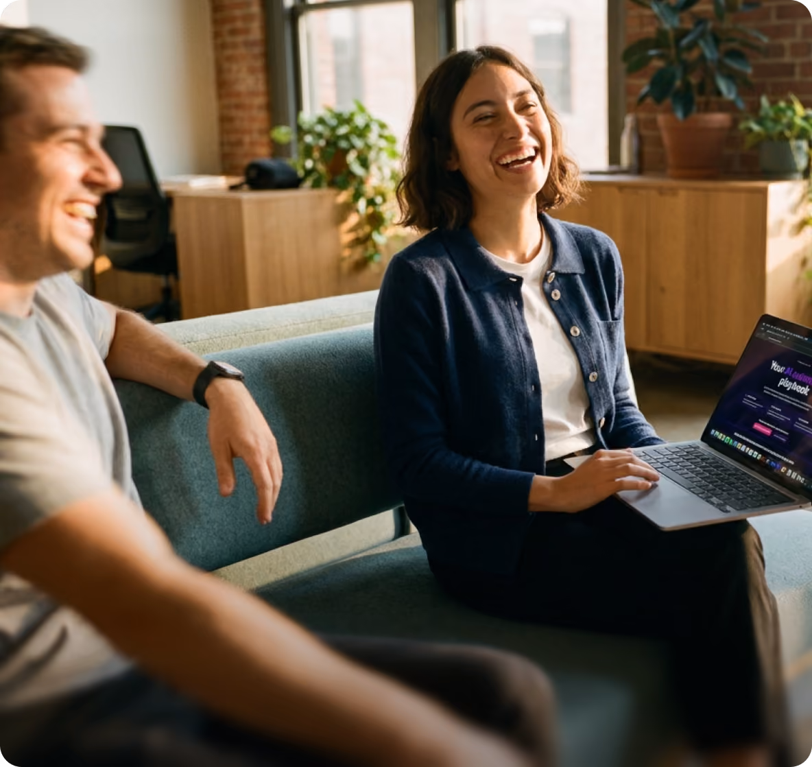 Team member laughing while working on a laptop
