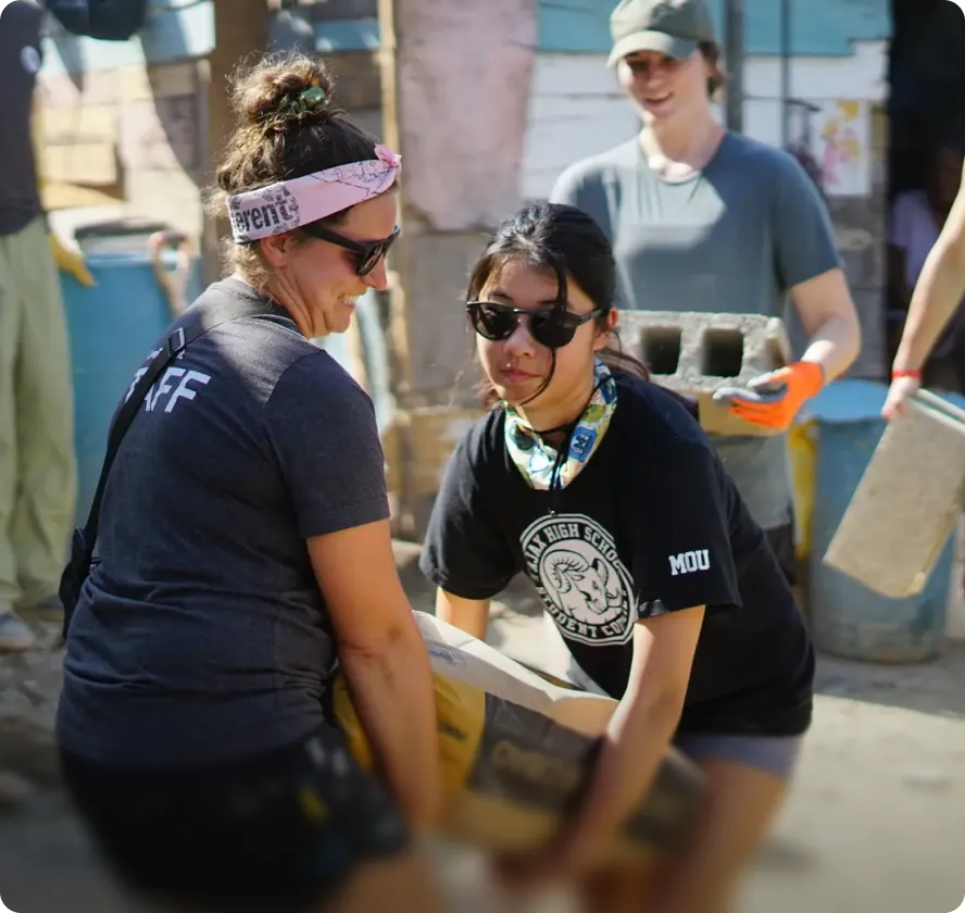Volunteers carrying supplies together outdoors
