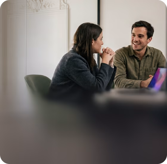 Two colleagues talking at a laptop