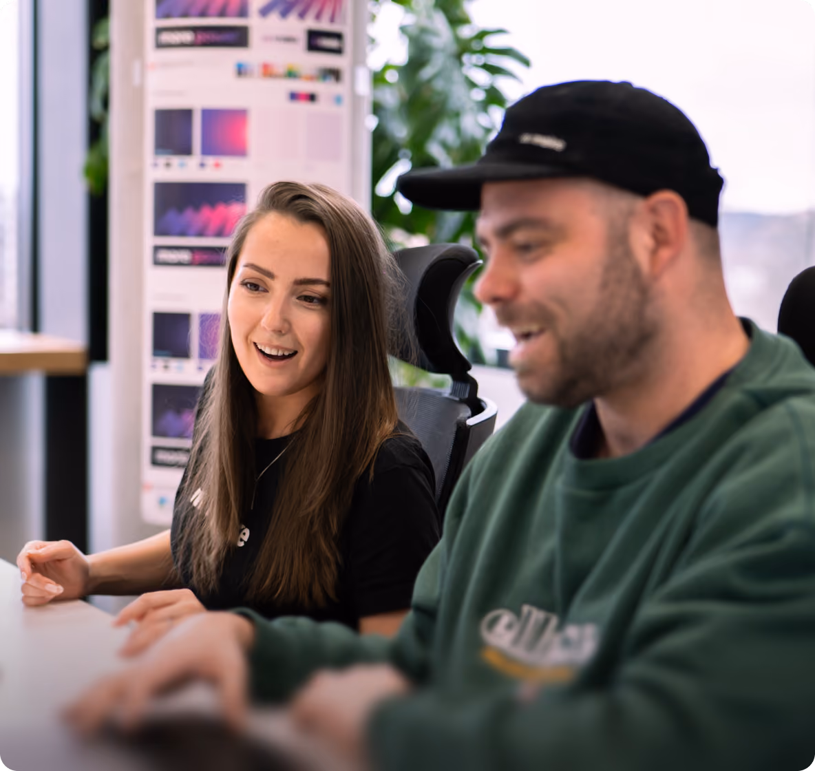 Startup founders laughing while working at a laptop