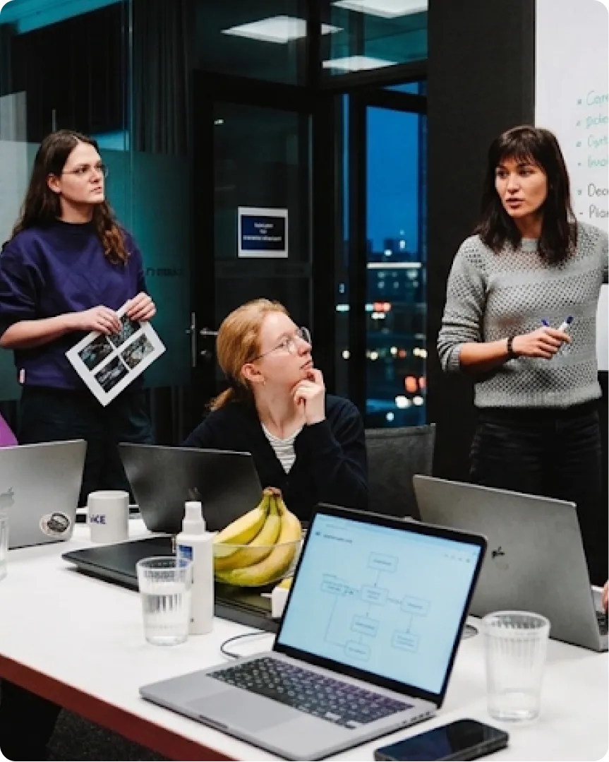 Marketing team discussing ideas around a laptop
