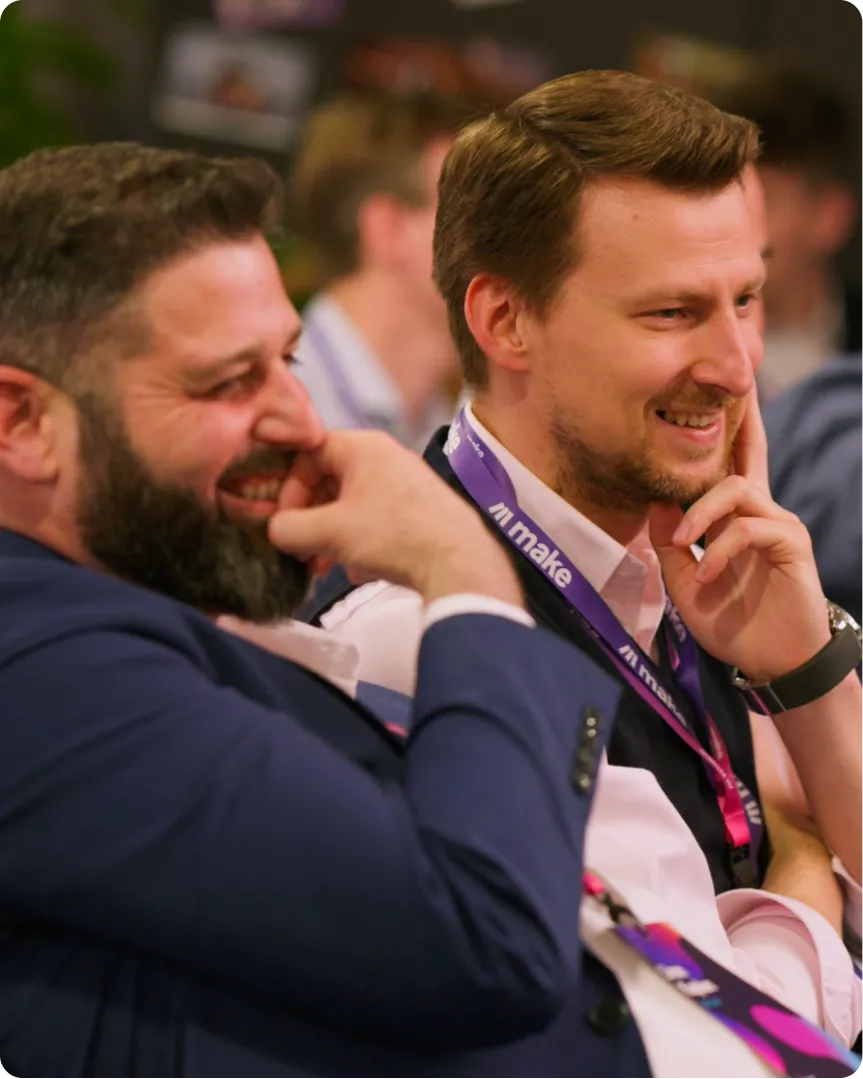 Two colleagues laughing at a Make event