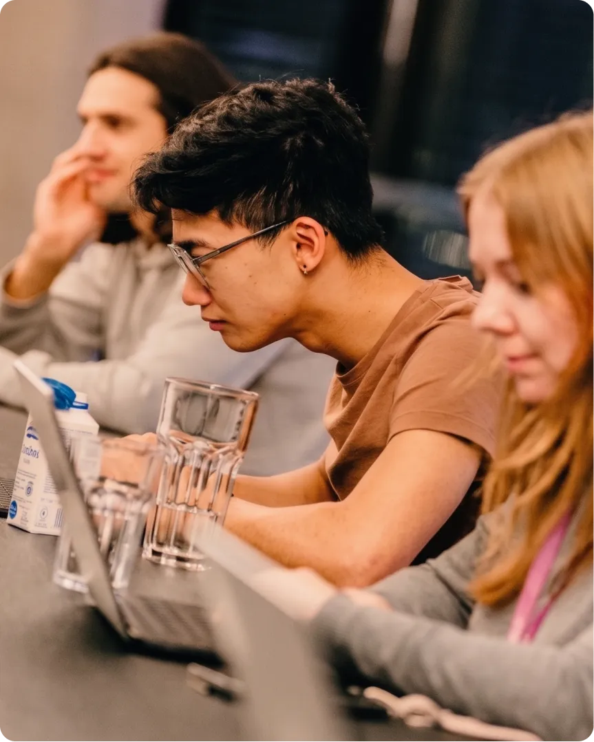 Engineers working on laptops at a hackathon