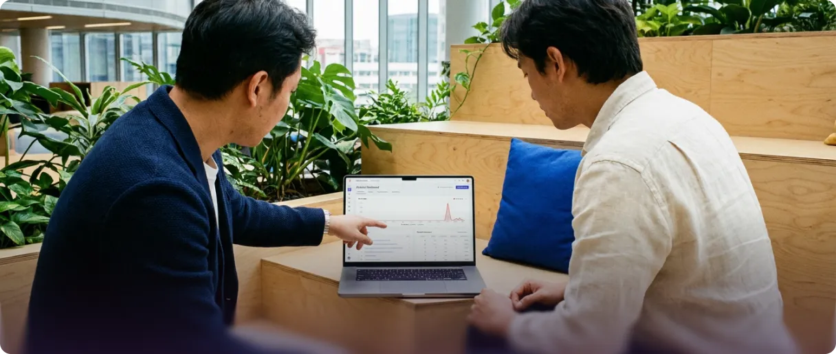 Two colleagues looking at a laptop in an office