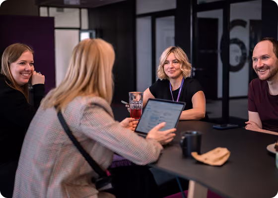 Team discussing a project on a tablet in a meeting room