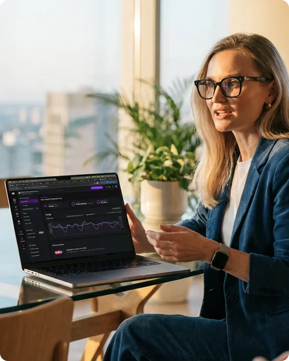 Woman reviewing a dashboard on a laptop by a window